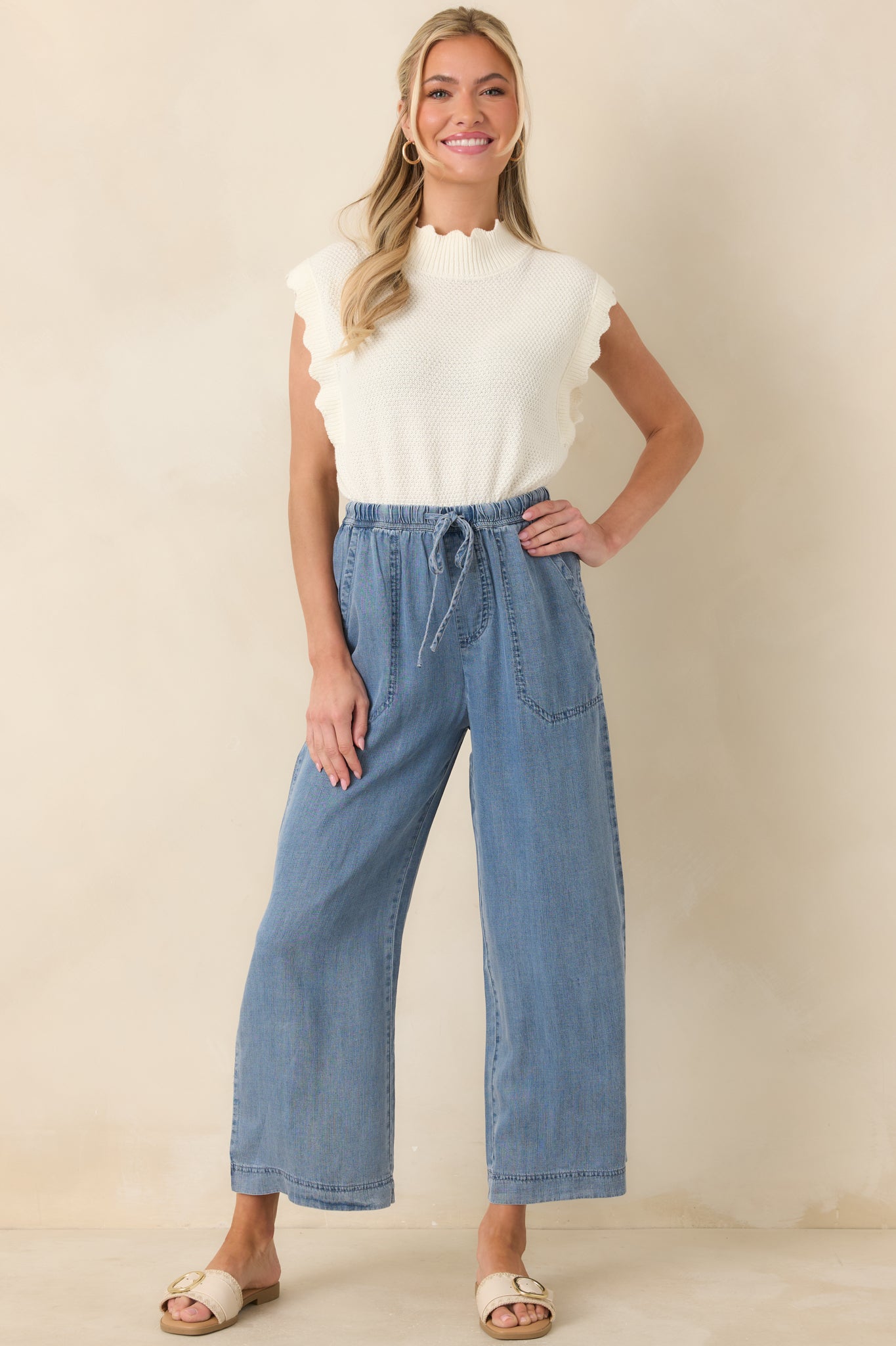 Front-facing view showing the cropped silhouette, wide ribbed hem, and delicate scalloped details on the white top.