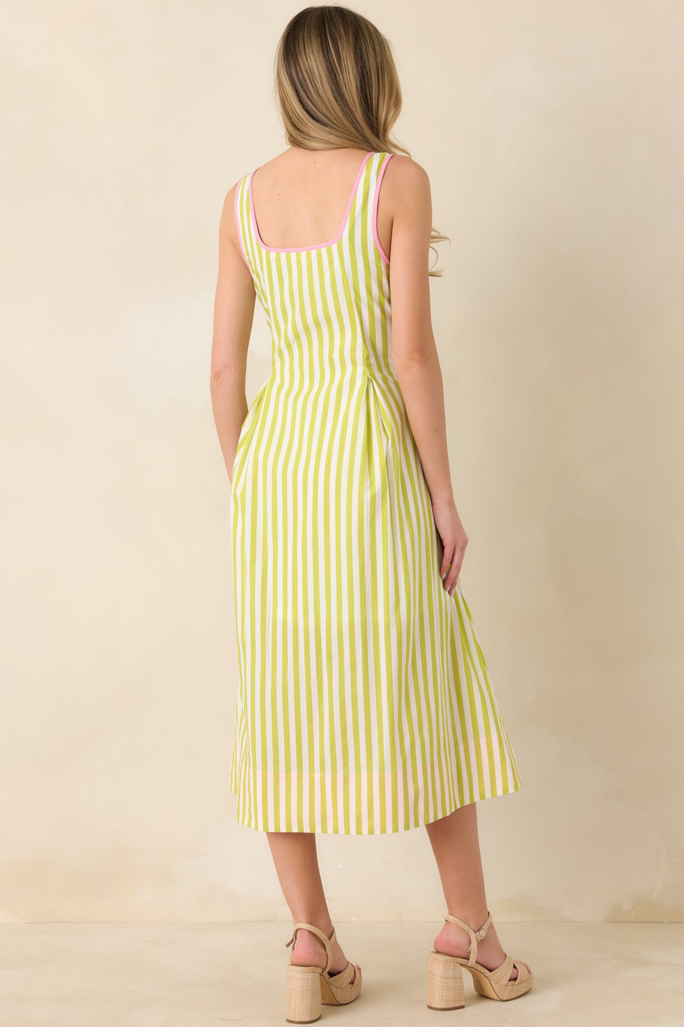 Back view of the green and pink striped midi dress featuring hidden side zipper and continuous stripe pattern.