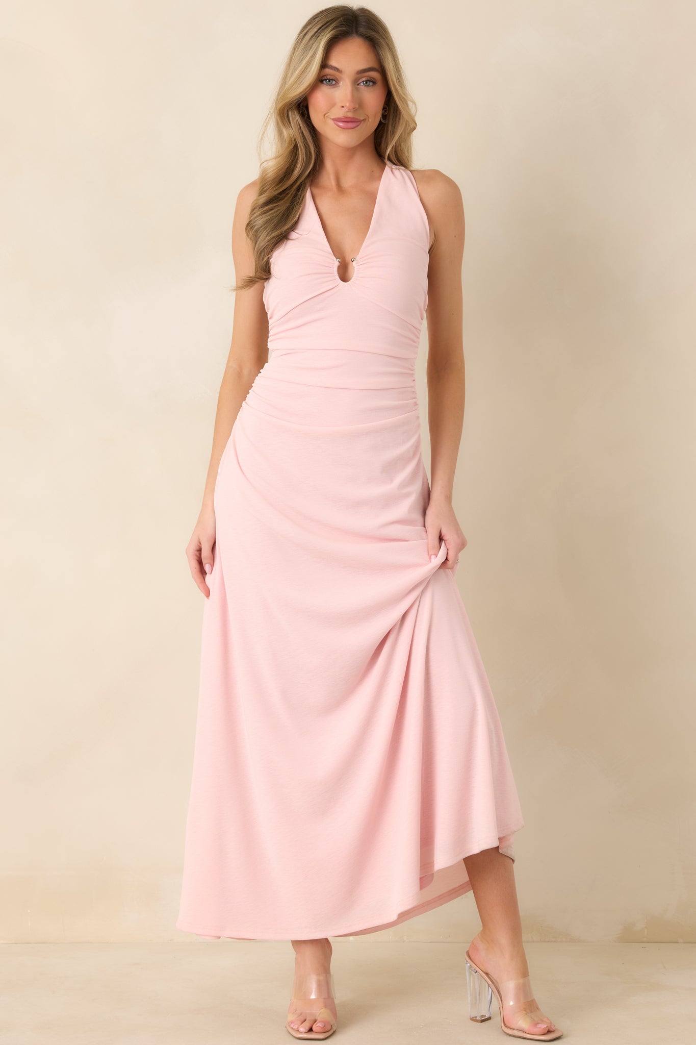 Front view of soft pink midi dress featuring halter neckline with gathered keyhole detail and ruched bodice.
