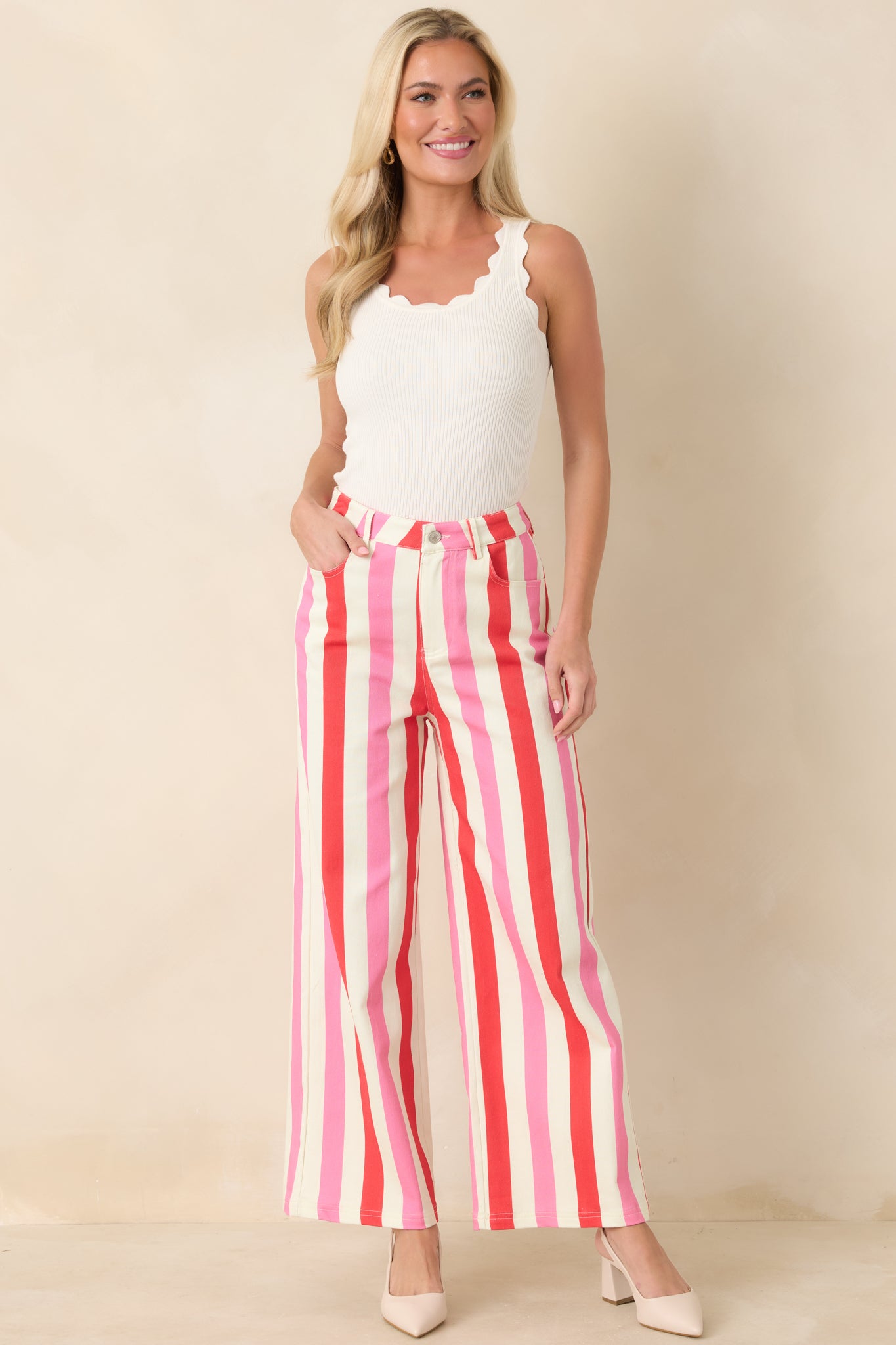White, red, and pink striped pants with flowing wide legs and vertical stripes for a polished look.