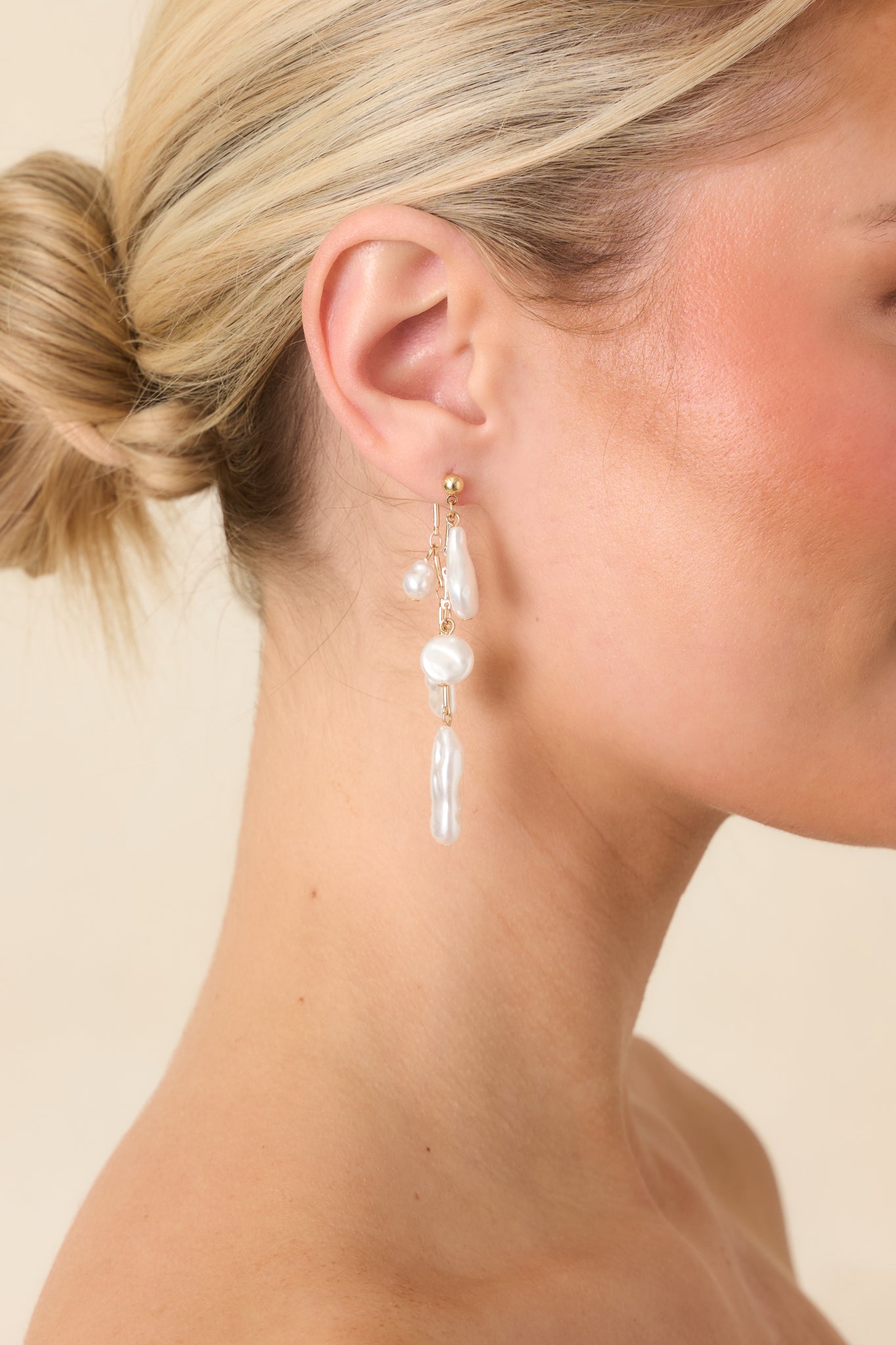 Close-up of irregular pearl accents on delicate gold chains, showcasing dimensional texture and elegant drop silhouette.