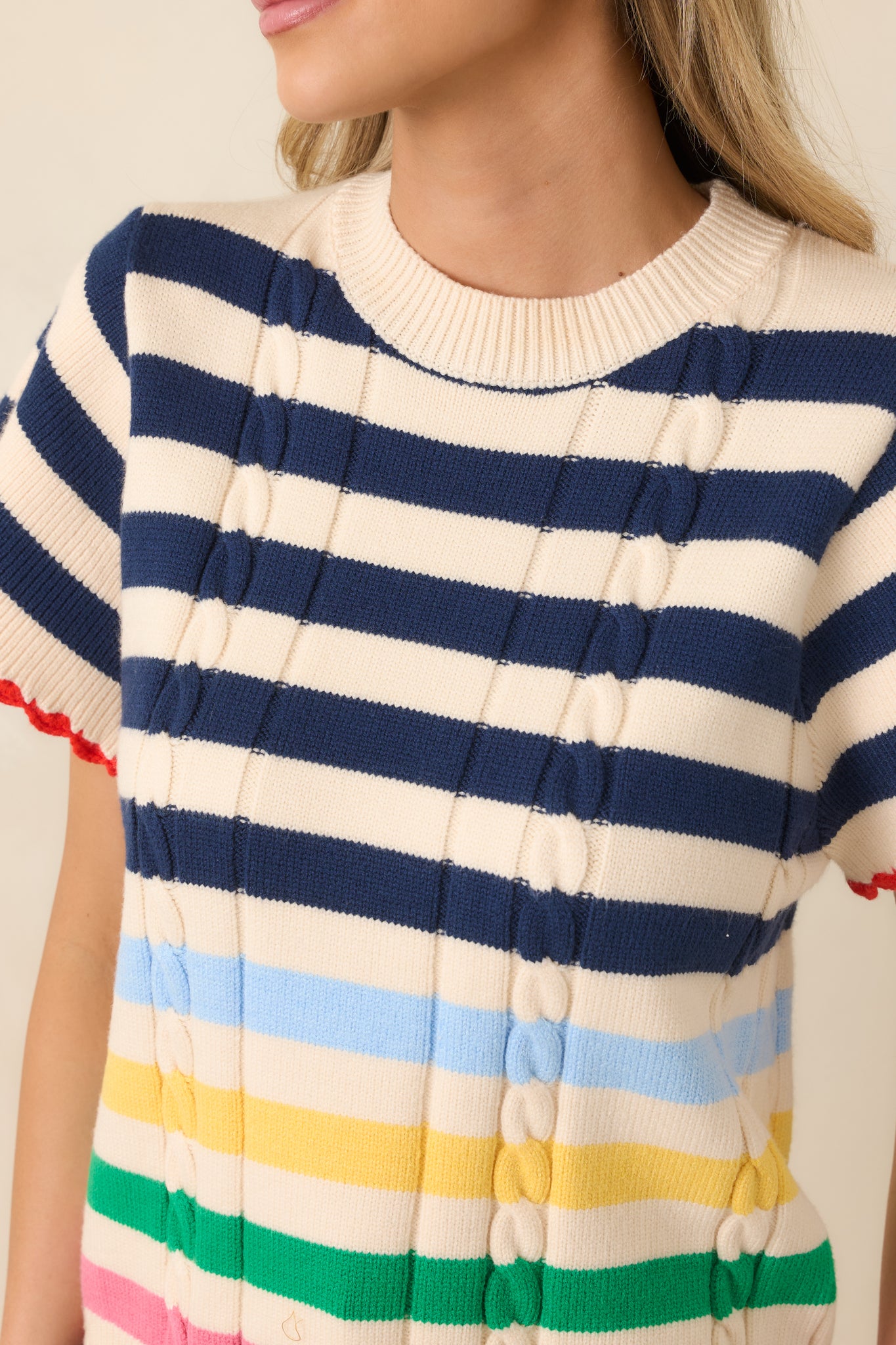 Textured knit fabric with navy stripes, colorful accents, and scalloped trim.