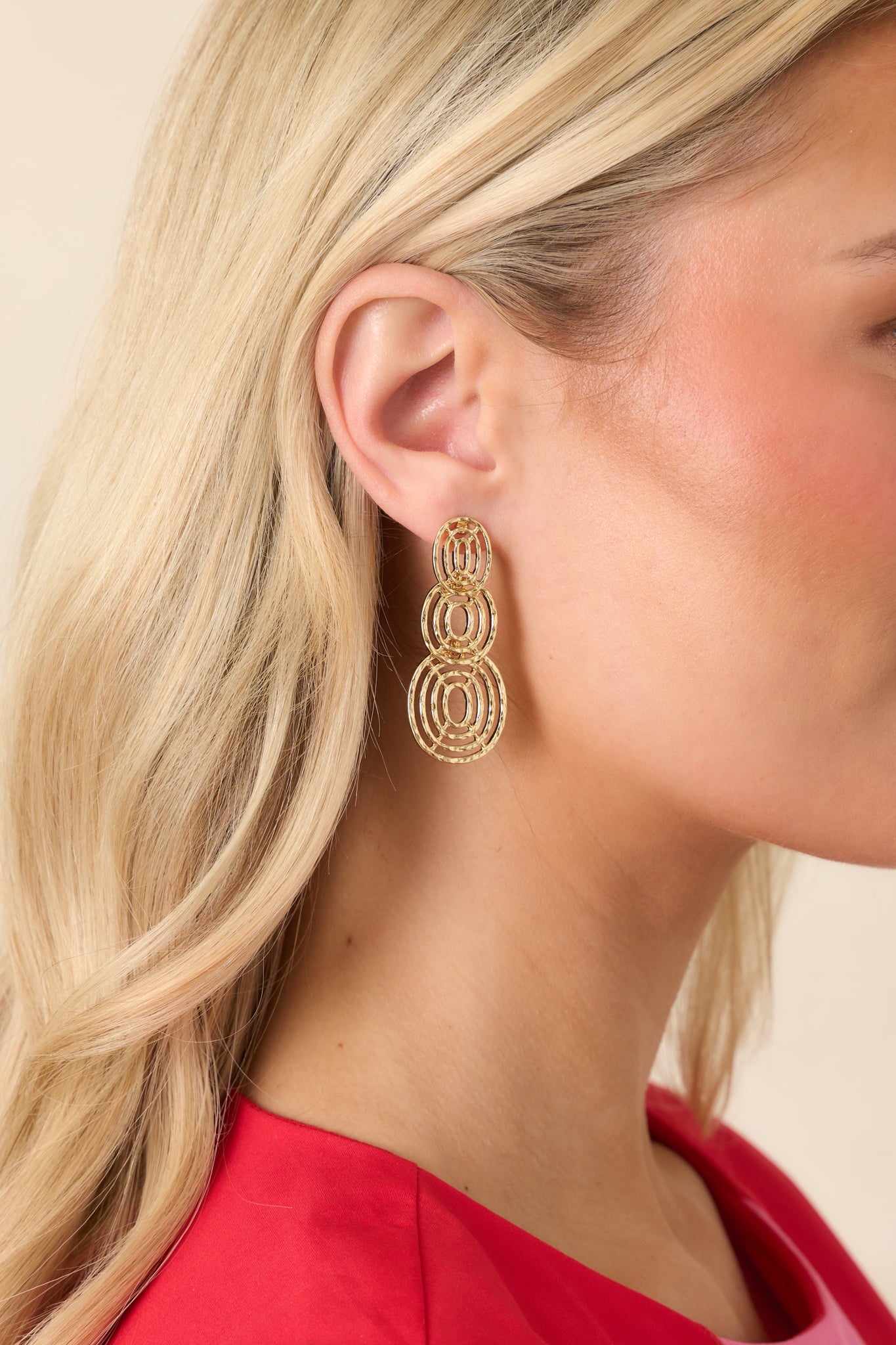 Gold circle drop earrings featuring three layered open hoops in a warm gold-tone finish.