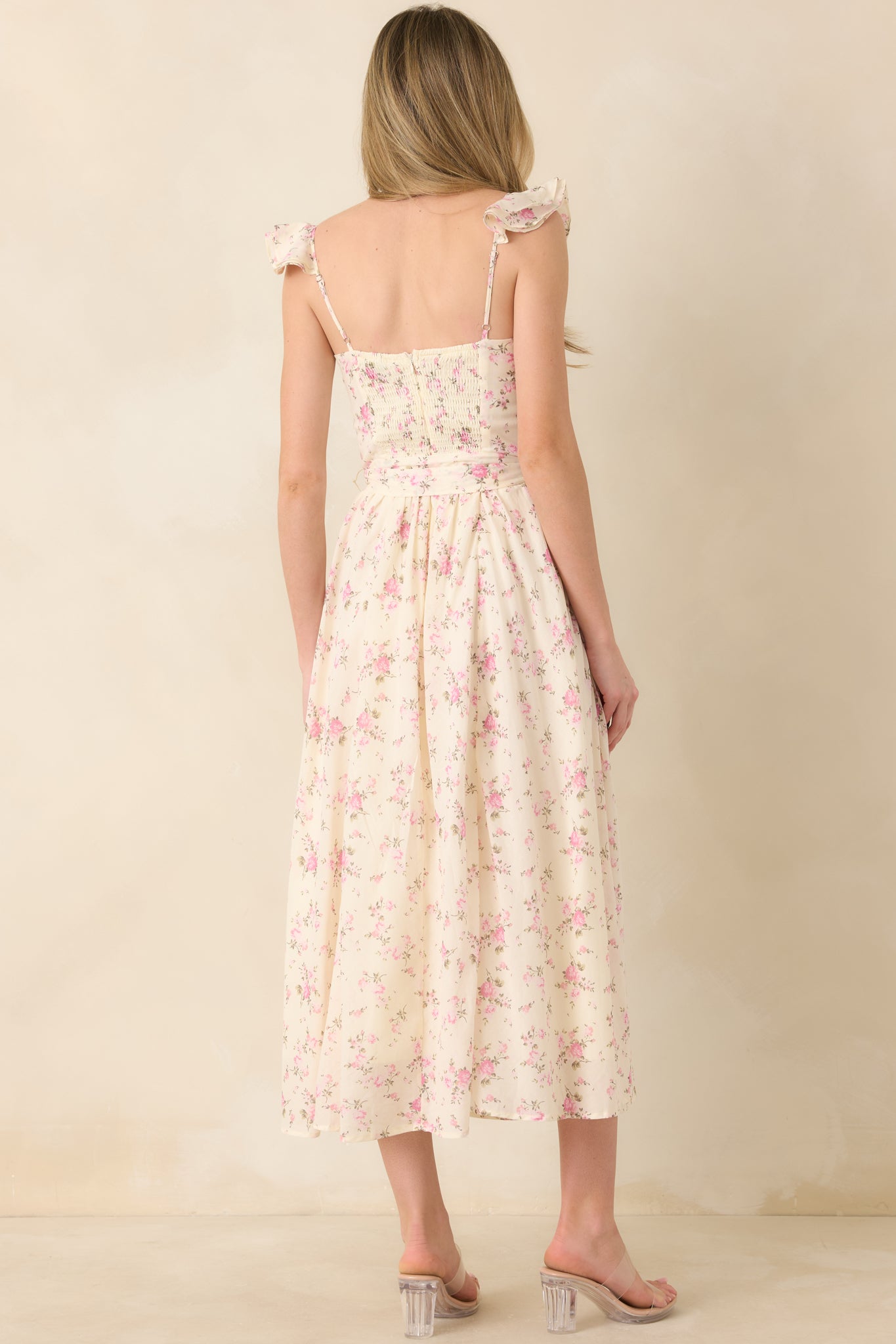 Back view of a light rose pink floral maxi dress with smocked panel, hidden zipper, and flowing skirt.