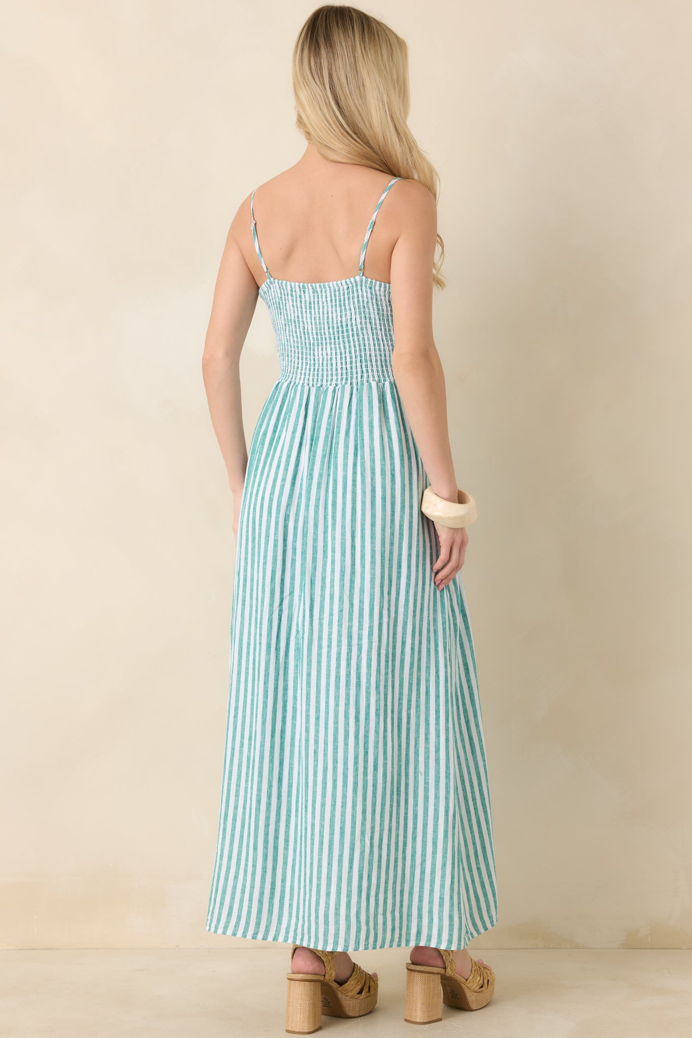 Back view of linen maxi dress with smocked bodice and flowing skirt, featuring thin adjustable straps.