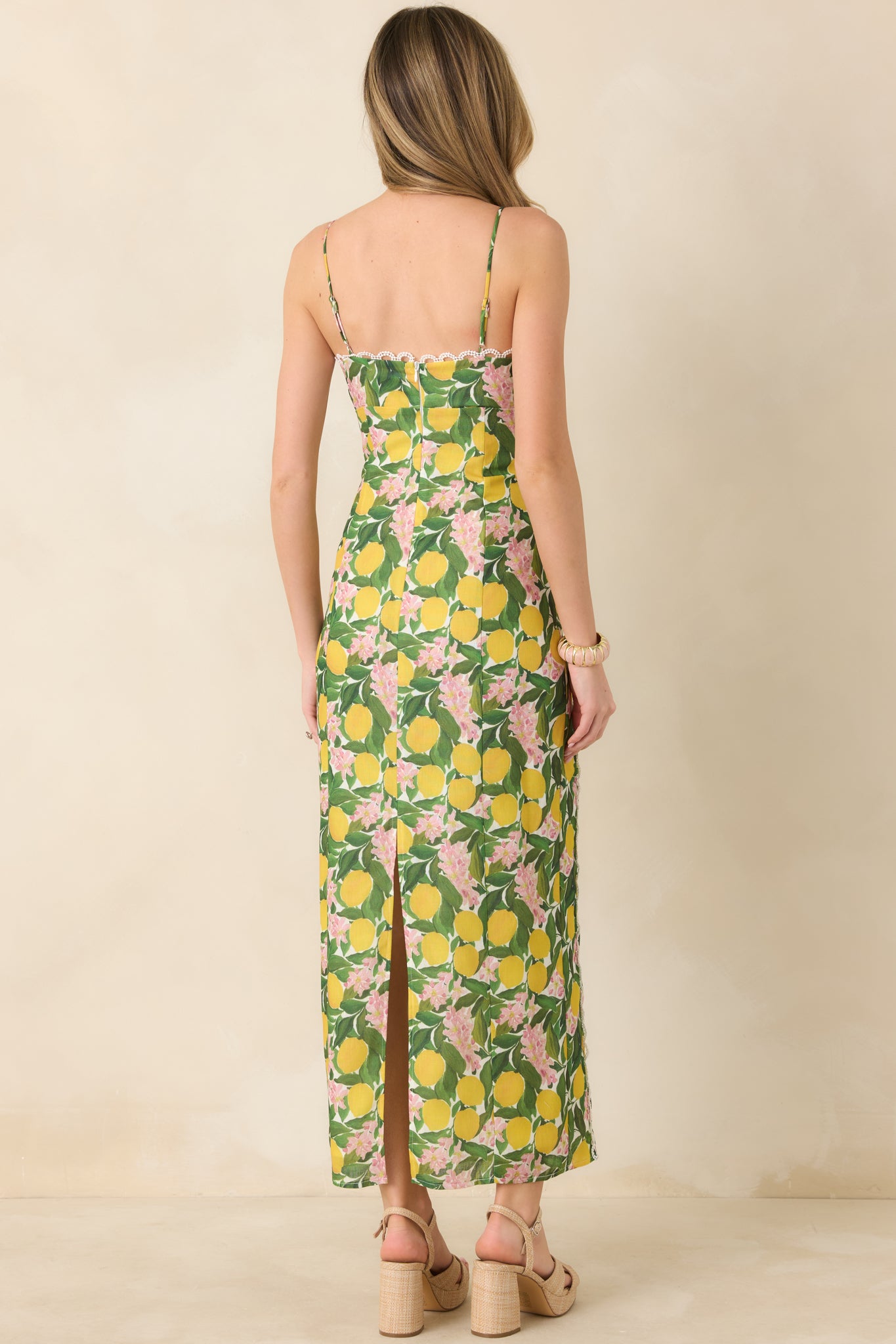 Rear view of the yellow multi maxi dress showcasing the concealed zipper closure and subtle back slit for ease of movement.