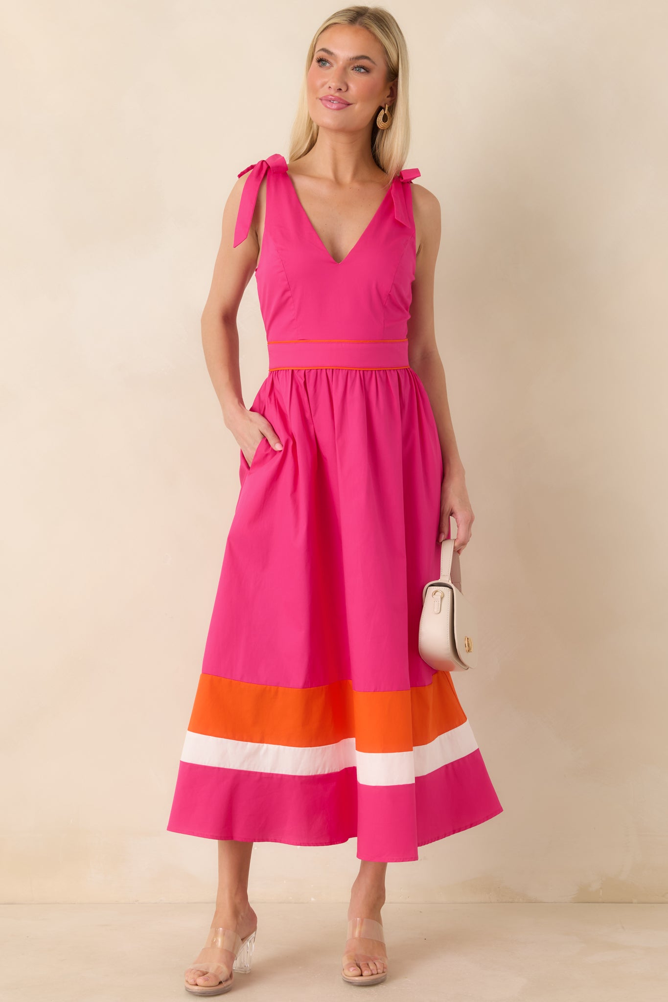 Flowy fuchsia midi dress with fitted waist and bold orange ivory colorblock hem.