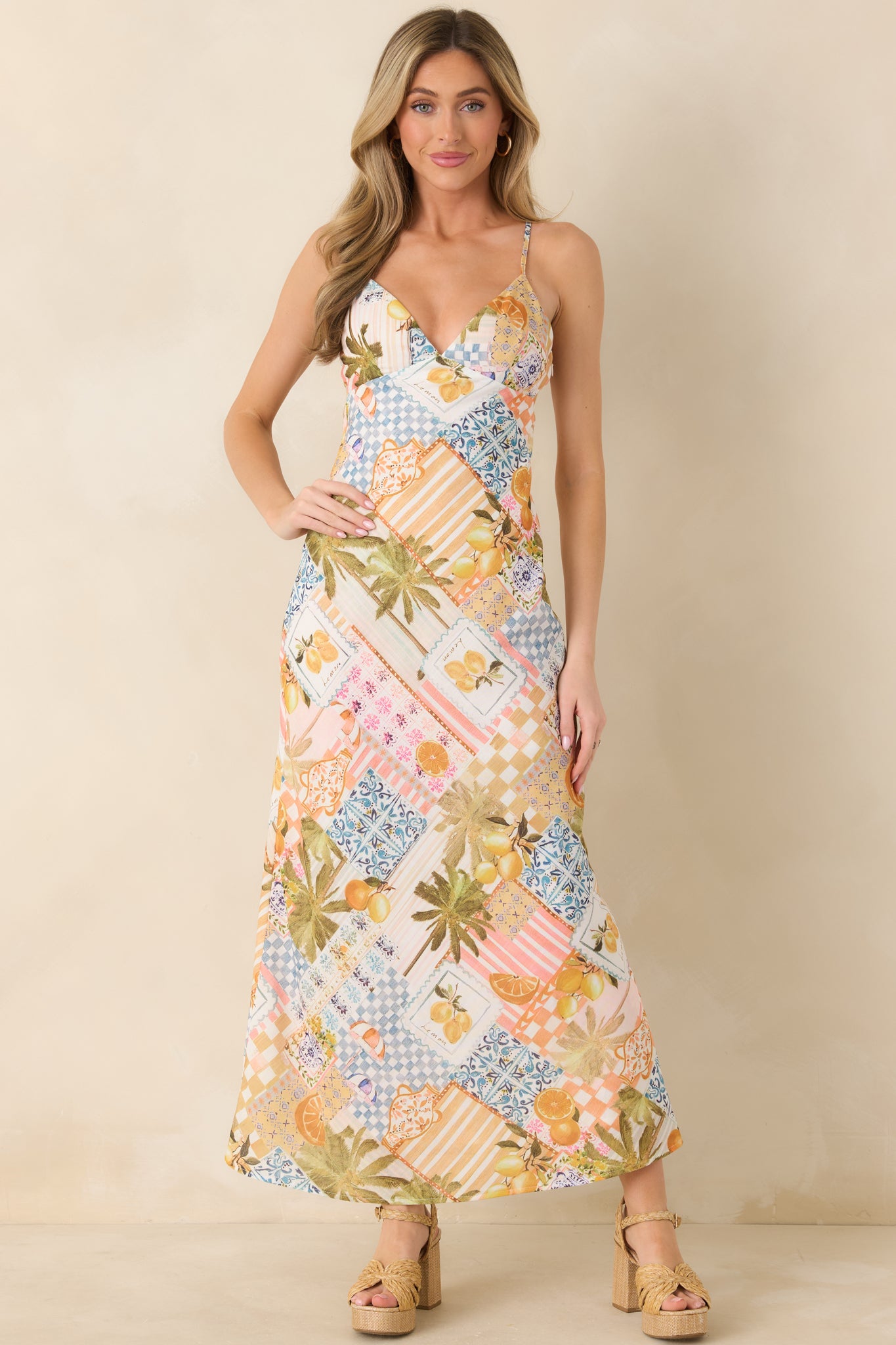 Vibrant patchwork dress combining tiled prints and tropical accents, tailored in a bias-inspired slip silhouette for effortless movement.