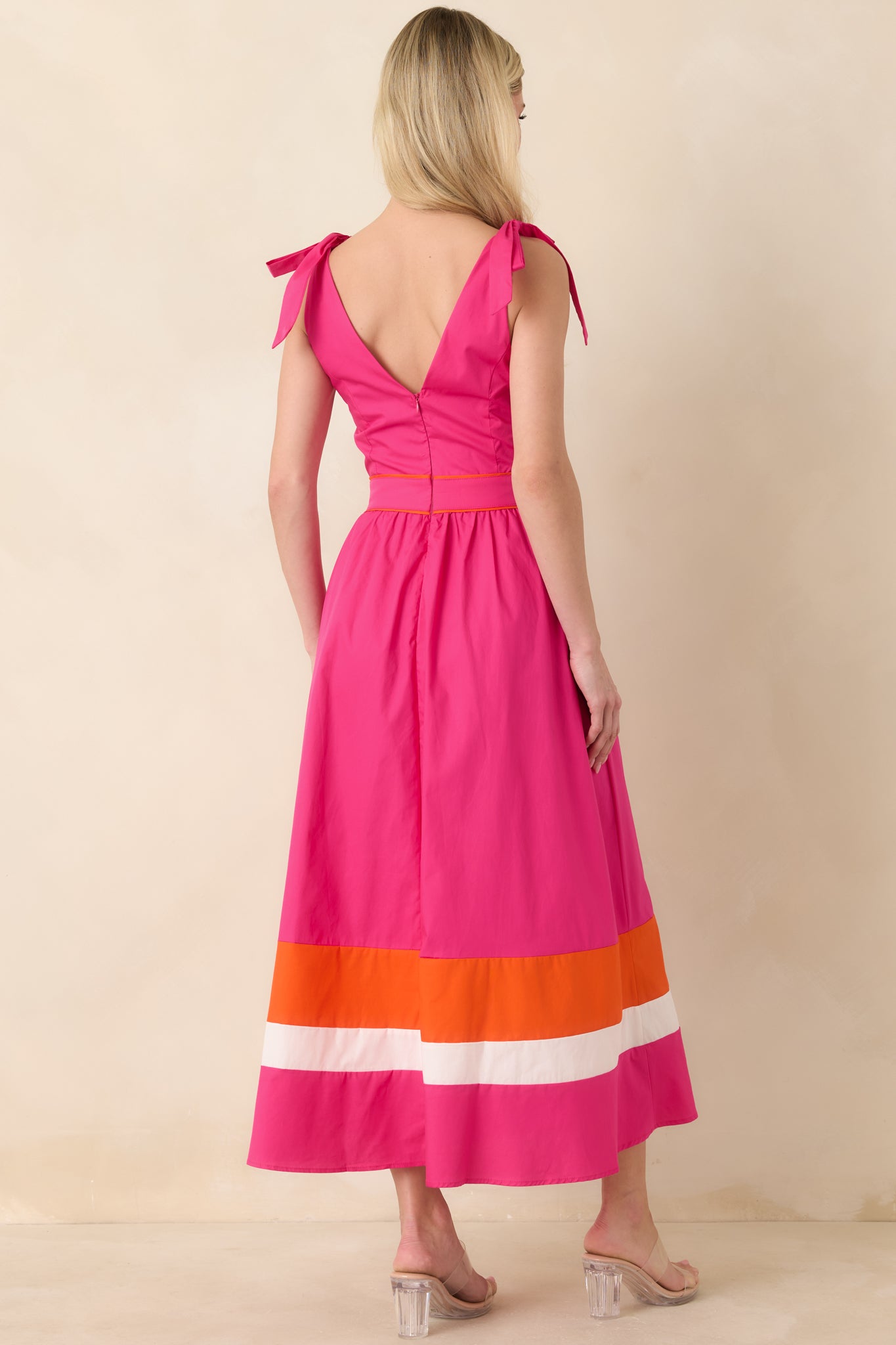 Fuchsia midi dress with adjustable tie shoulder straps and flowing skirt with contrast hem.