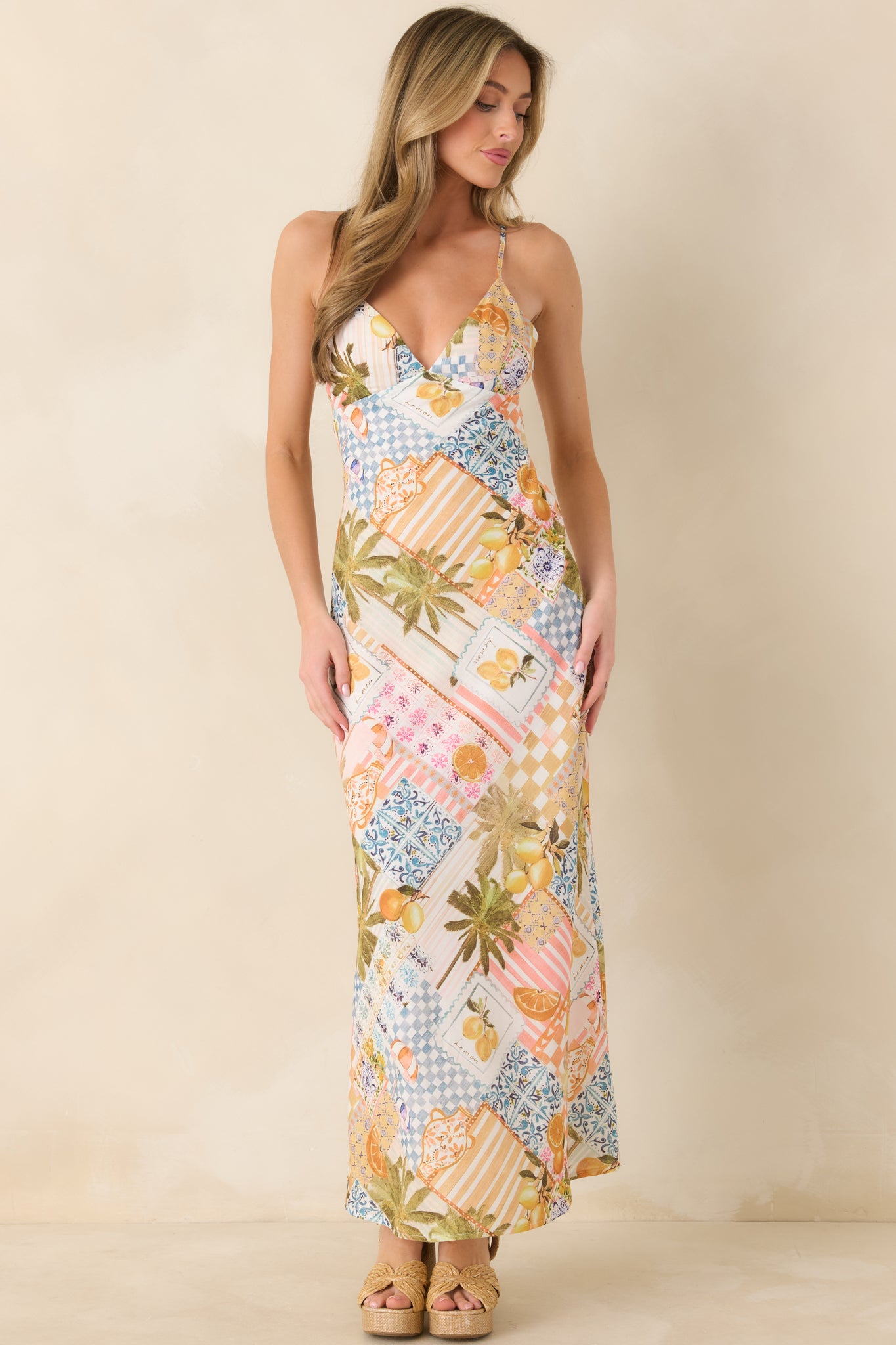 Front view of a patterned dress highlighting palm and citrus motifs in a streamlined slip design with elegant drape.