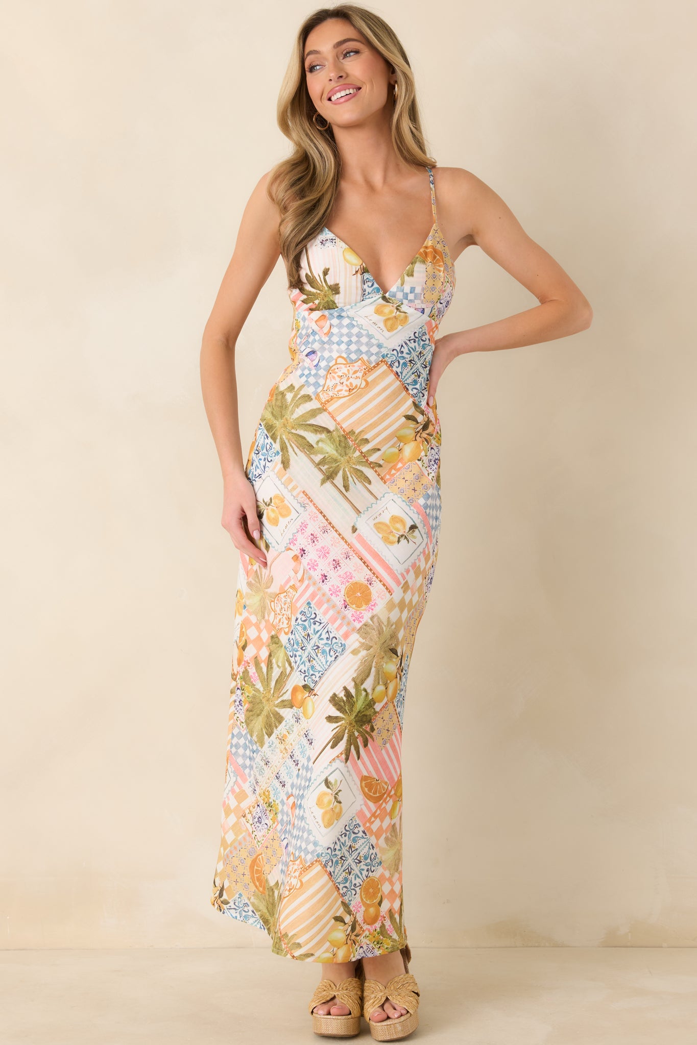 Mediterranean-inspired slip dress featuring a vibrant patchwork of citrus motifs, tiled prints, and palm accents with a sleek bias-cut silhouette.
