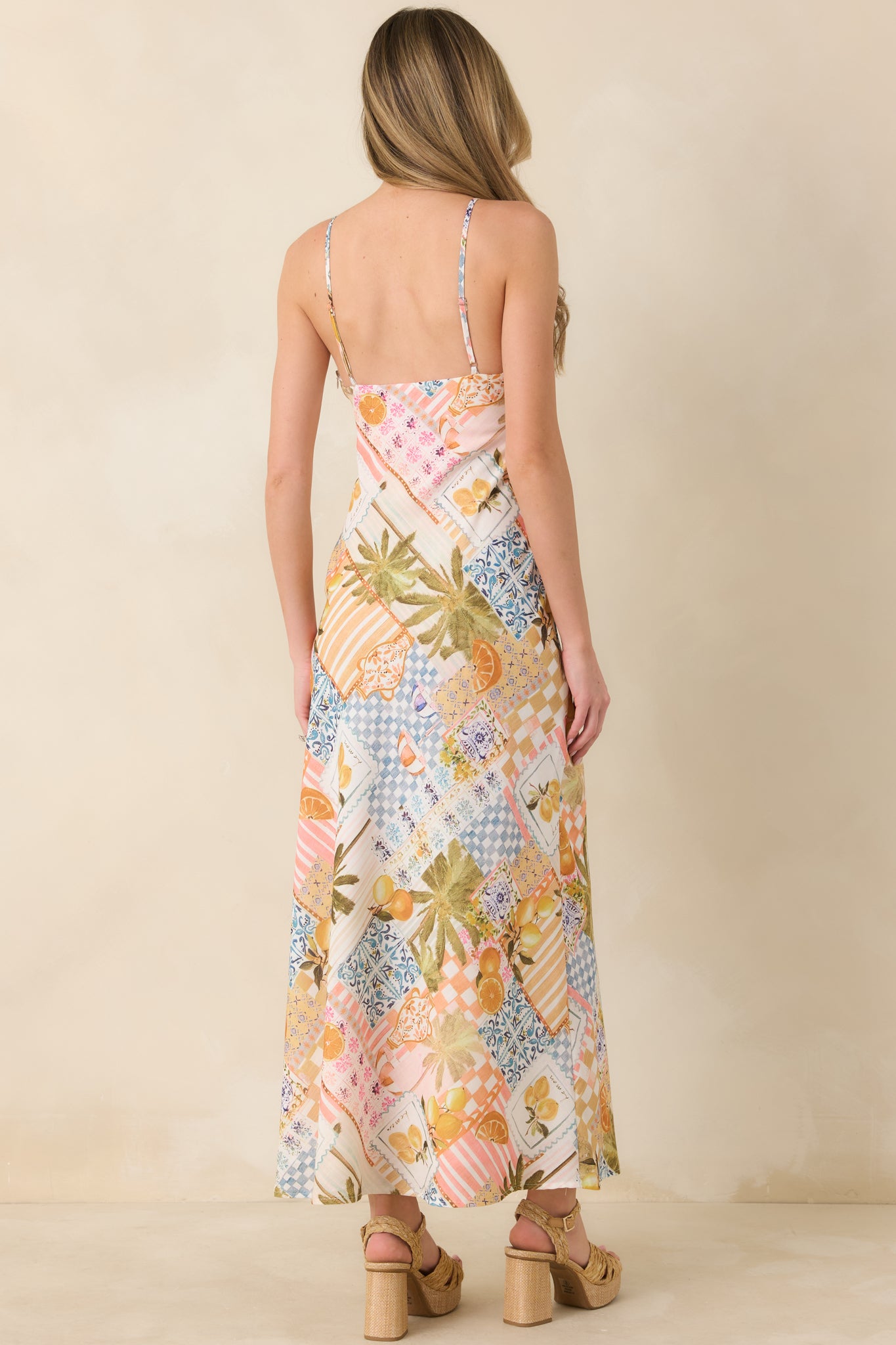 Rear view of the slip-style dress showcasing the bias-inspired drape and continuous vibrant patchwork pattern.