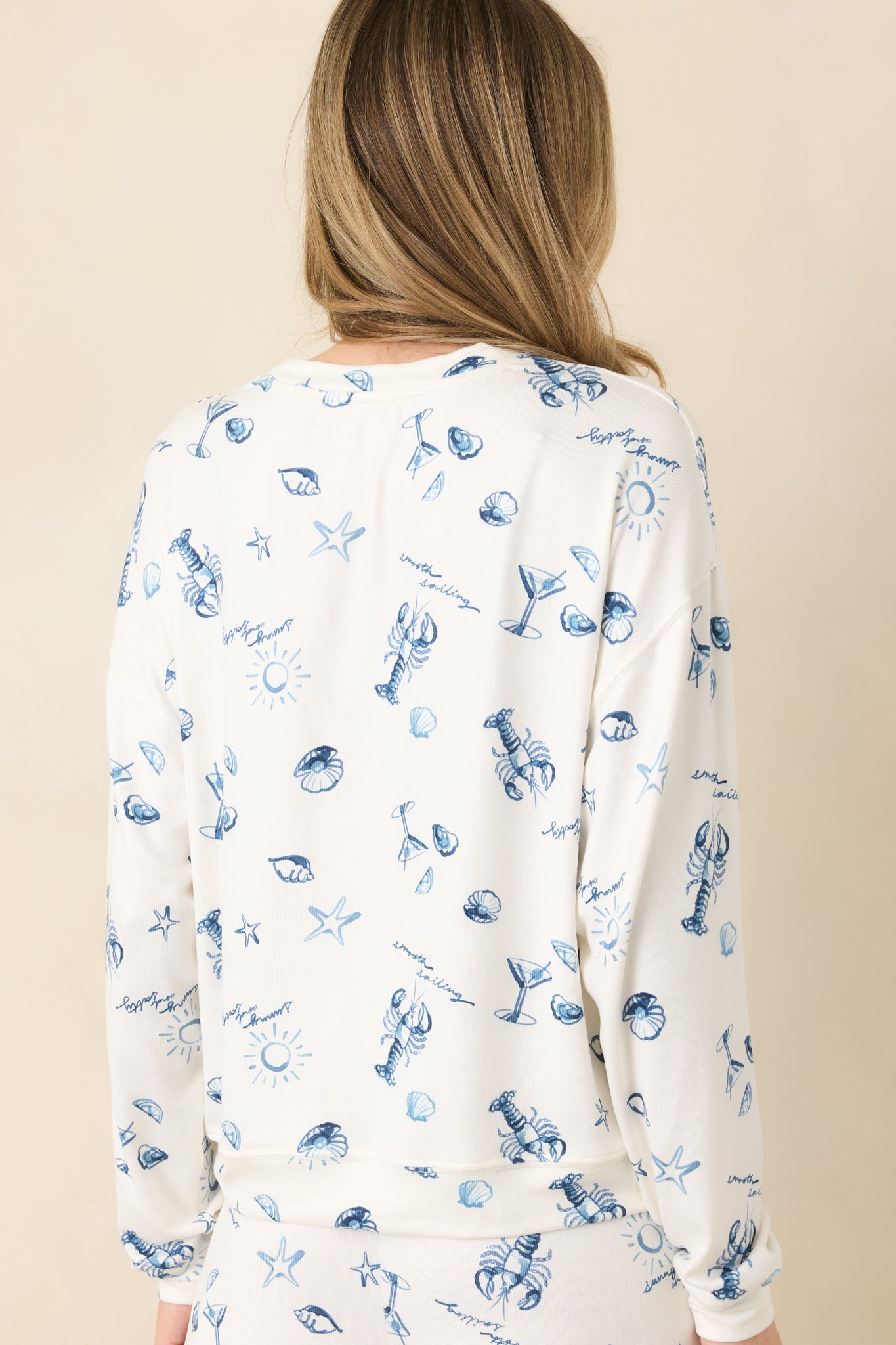 Rear view of ivory pullover with relaxed silhouette and long sleeves.