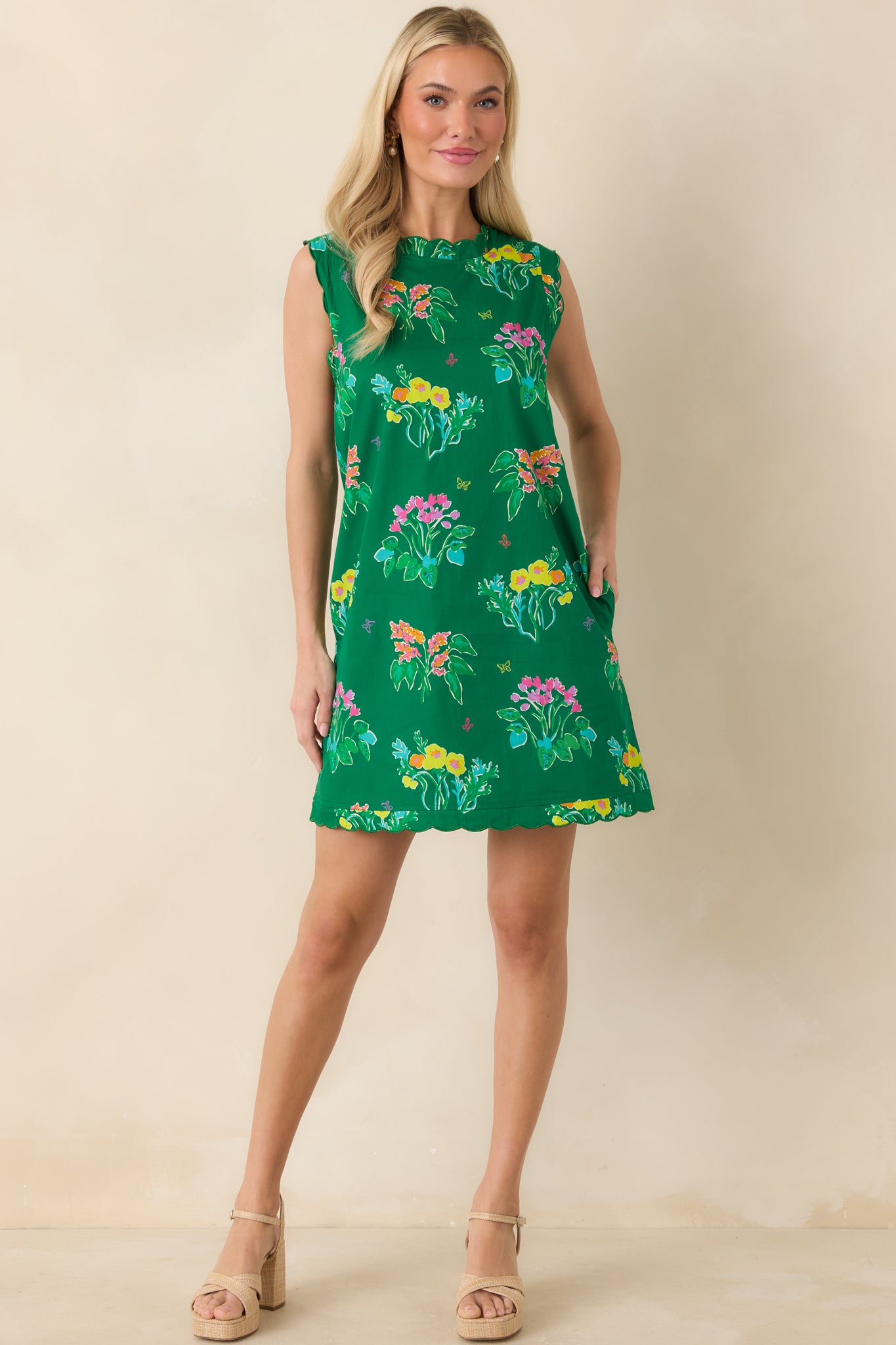 Sleeveless mini dress in vibrant green with colorful floral print and relaxed shift silhouette.