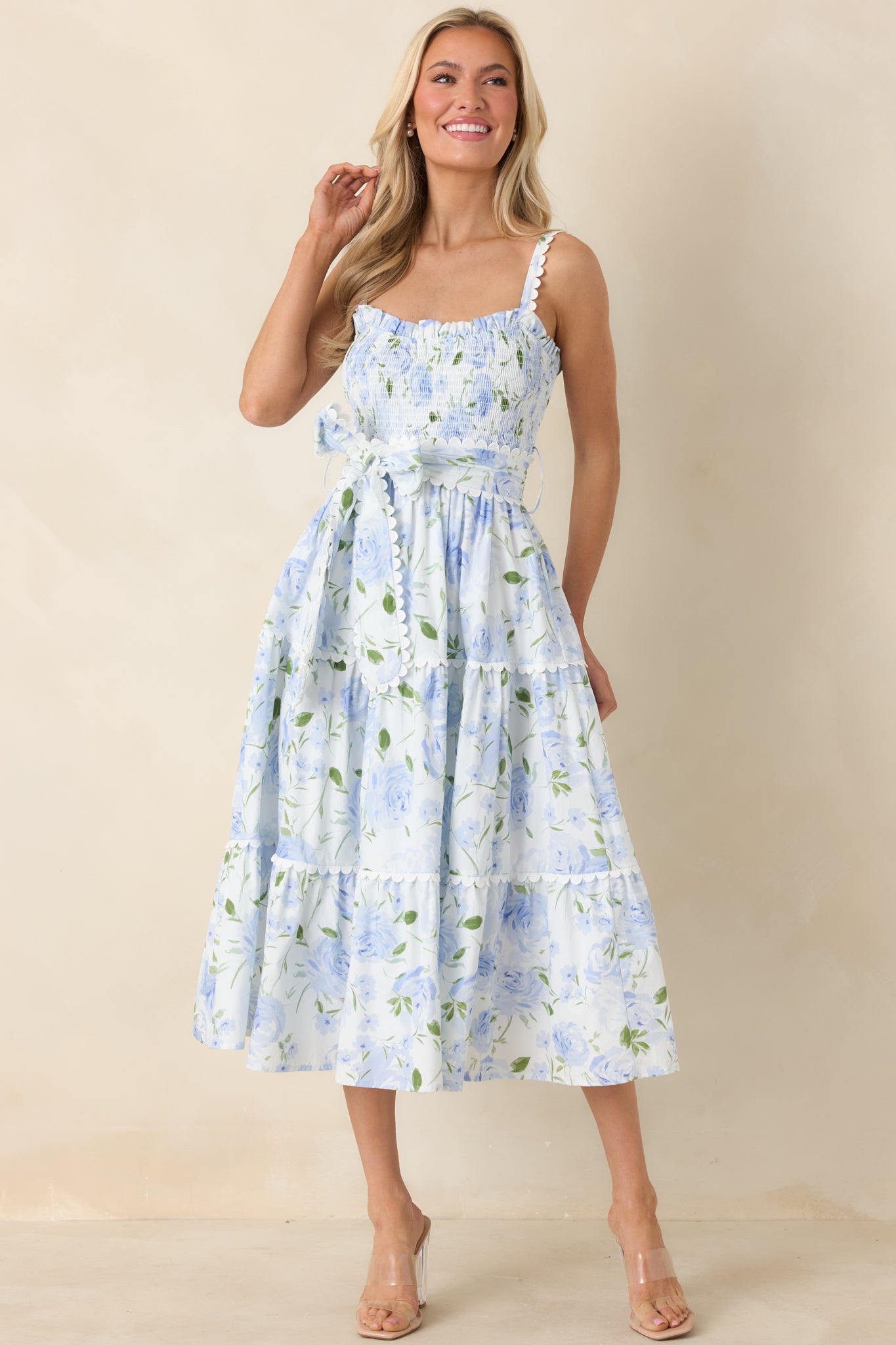 Soft blue maxi dress with smocked bodice, adjustable straps, and flowing tiered hem for airy movement.