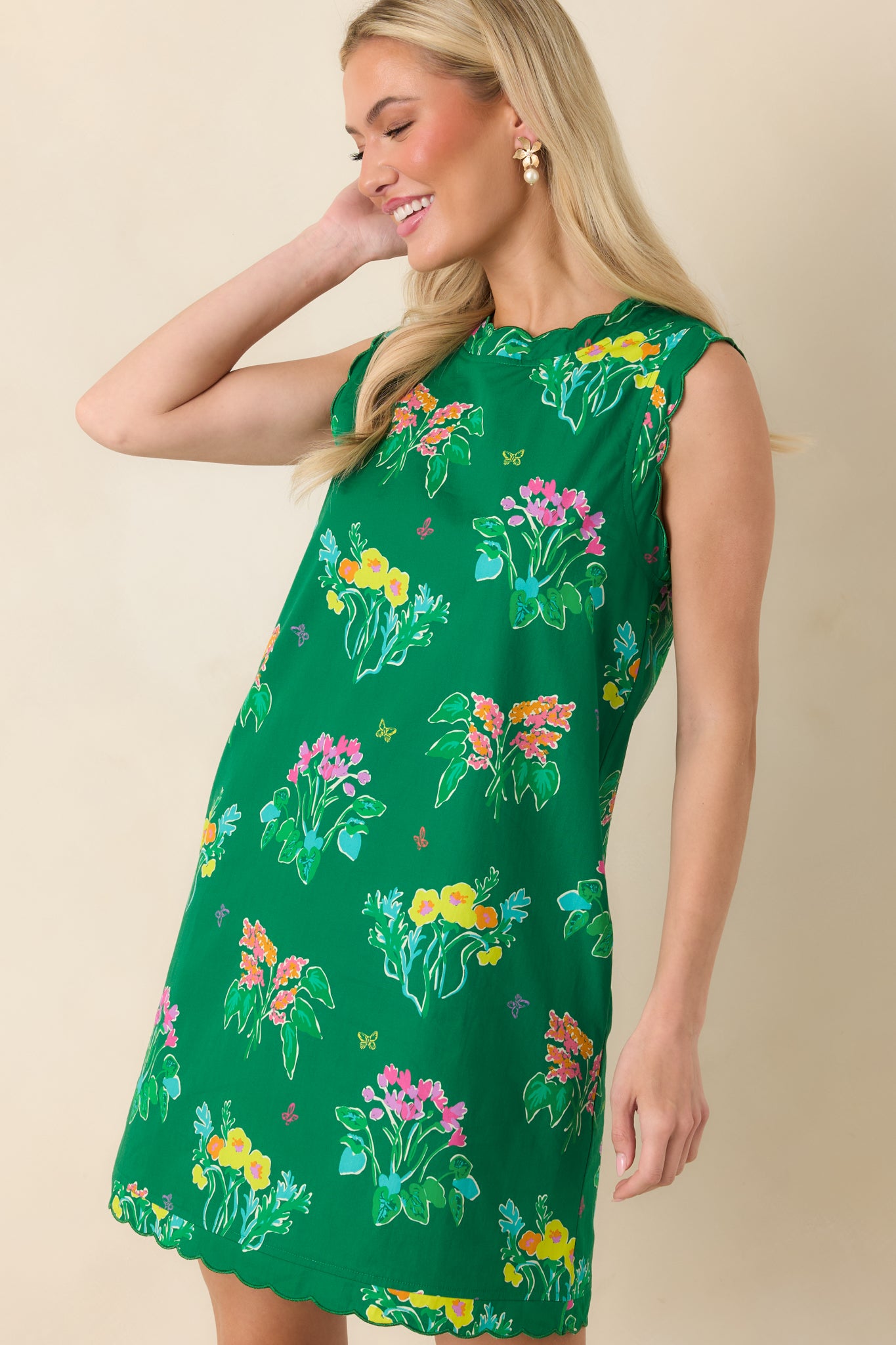 Detail of scalloped neckline and bright floral print on lightweight cotton mini dress.