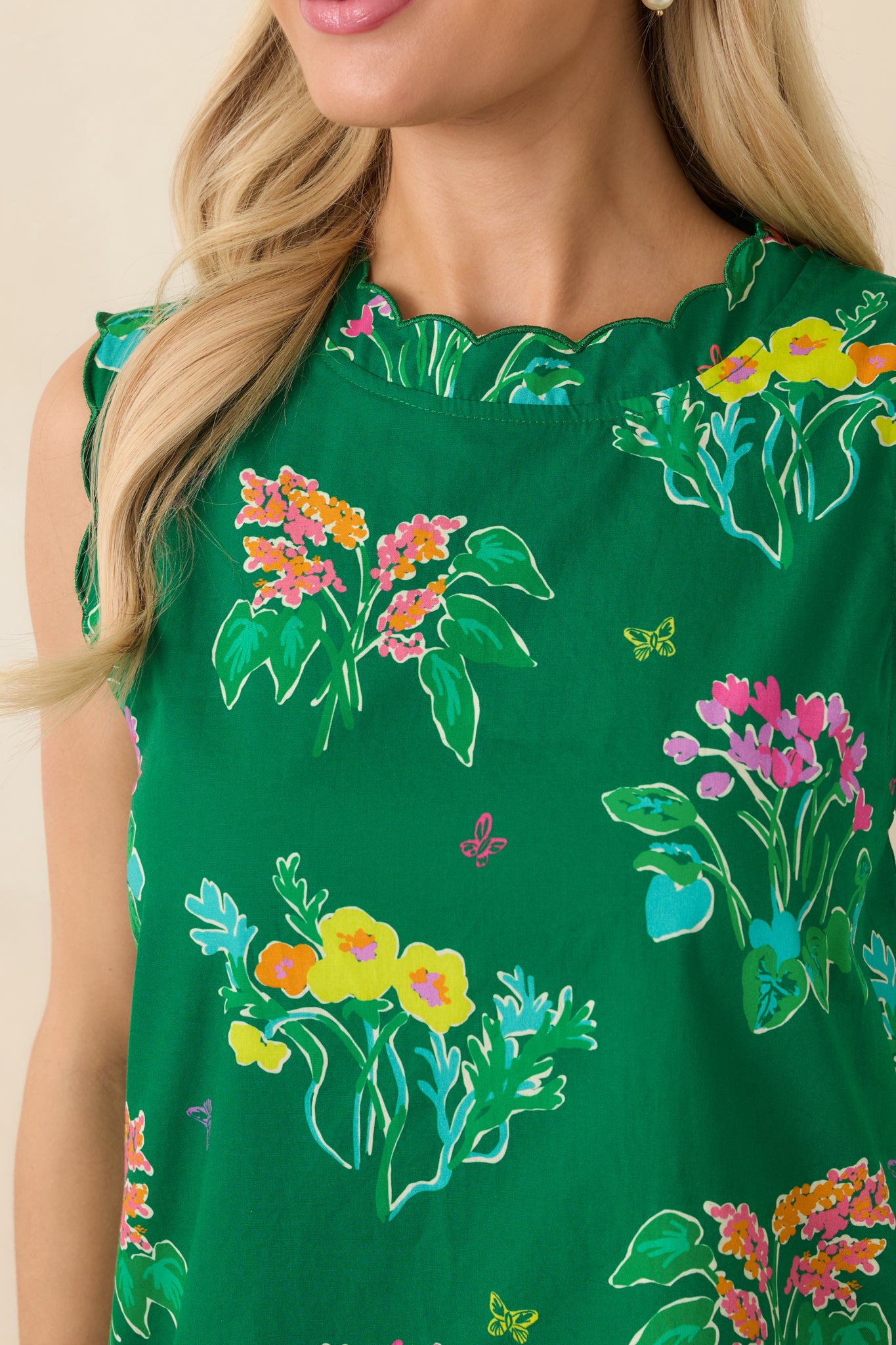 Close-up of cotton mini dress showing scalloped neckline, hem, and colorful floral pattern.
