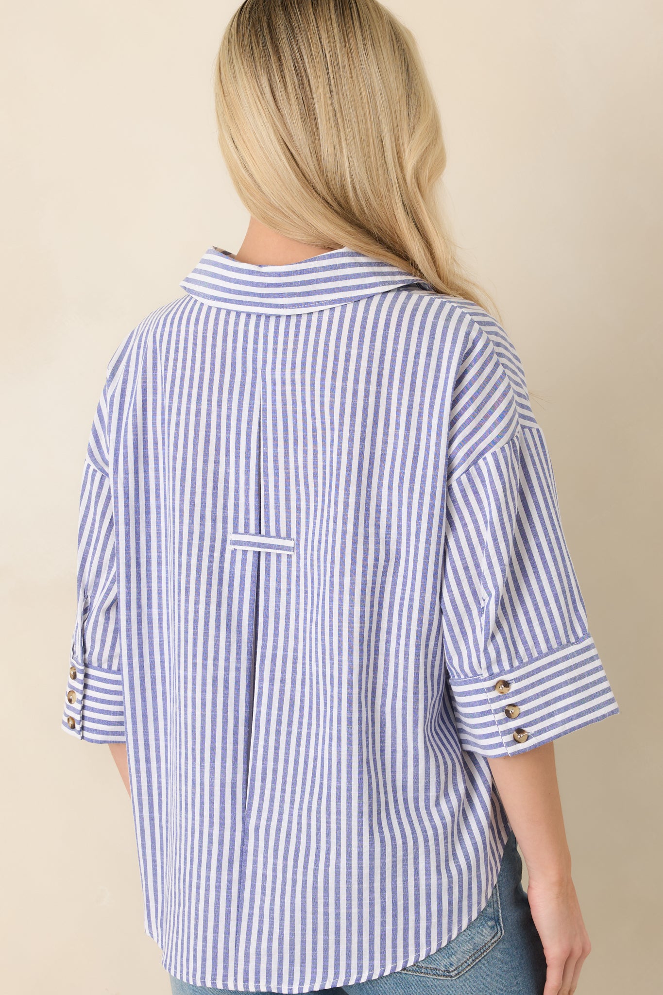 Back view of the blue and white vertical stripe blouse featuring relaxed fit and uninterrupted stripe pattern.