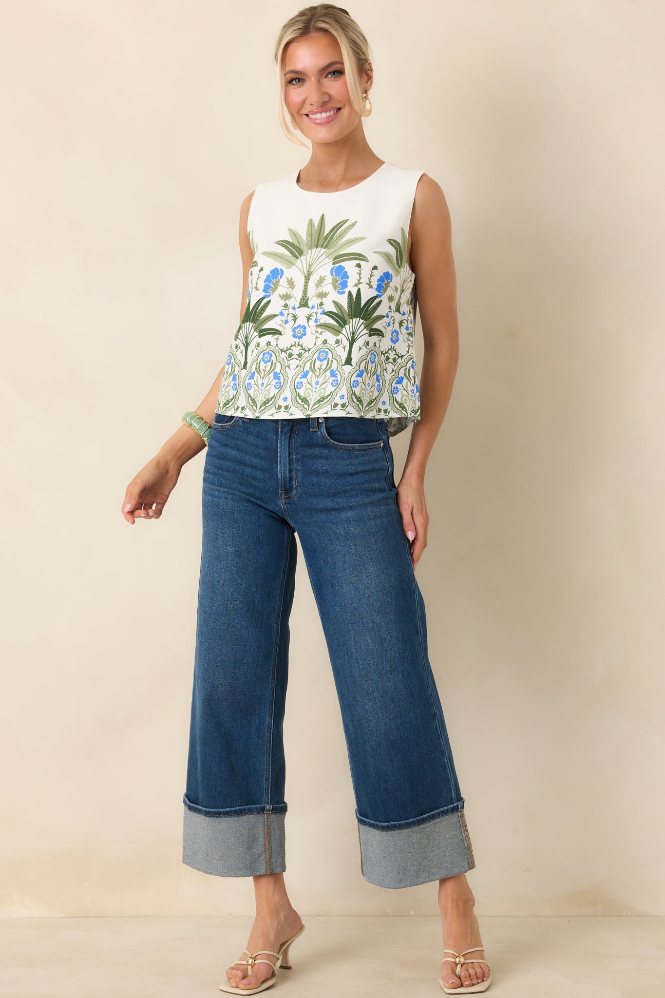 Ivory sleeveless top with multi floral pattern and relaxed cropped silhouette.