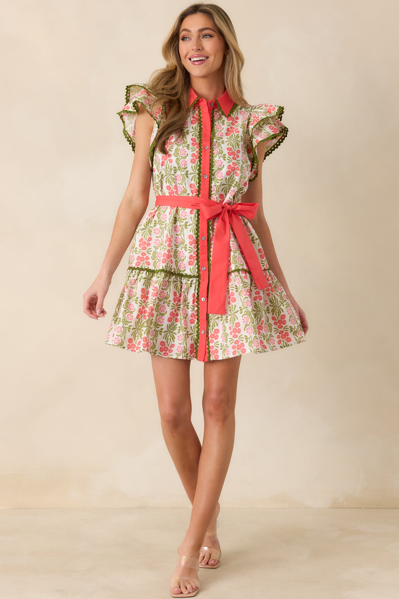 Front-facing full-length view of the coral pink mini dress with a collared neckline and allover green and pink floral print.