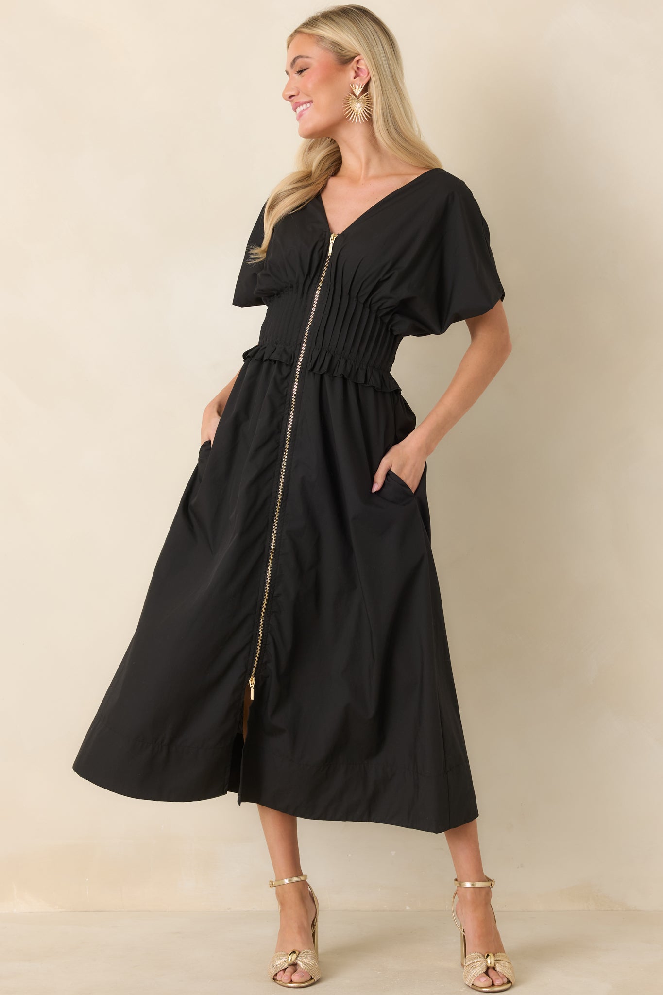 Relaxed A-line maxi featuring front zip closure, side pockets, and a structured smocked waist with ruffle detail.