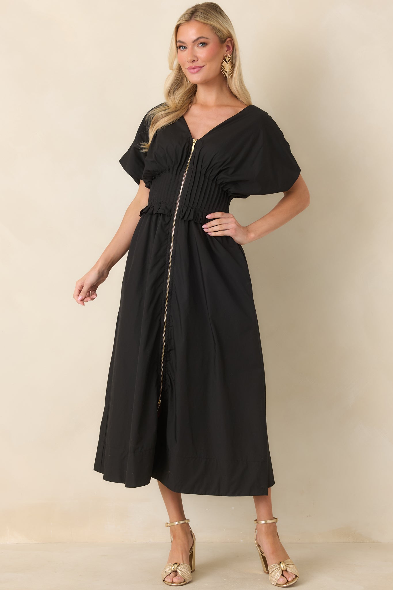 Woven black maxi with a wide smocked waistband, subtle ruffle trim, and functional side pockets.
