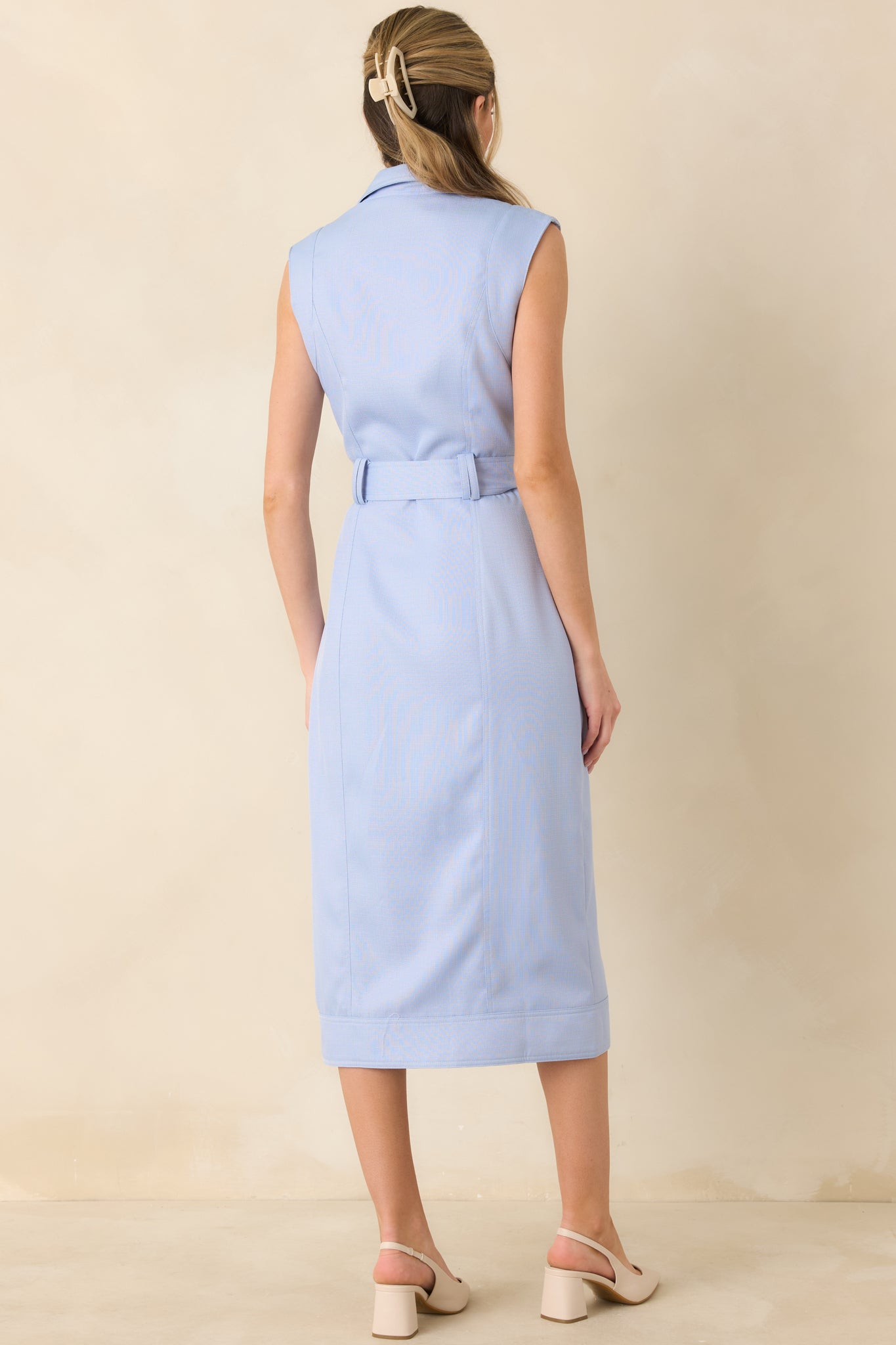 Rear view of blue sleeveless midi dress showing the smooth woven fabric, streamlined silhouette, and midi-length hemline.