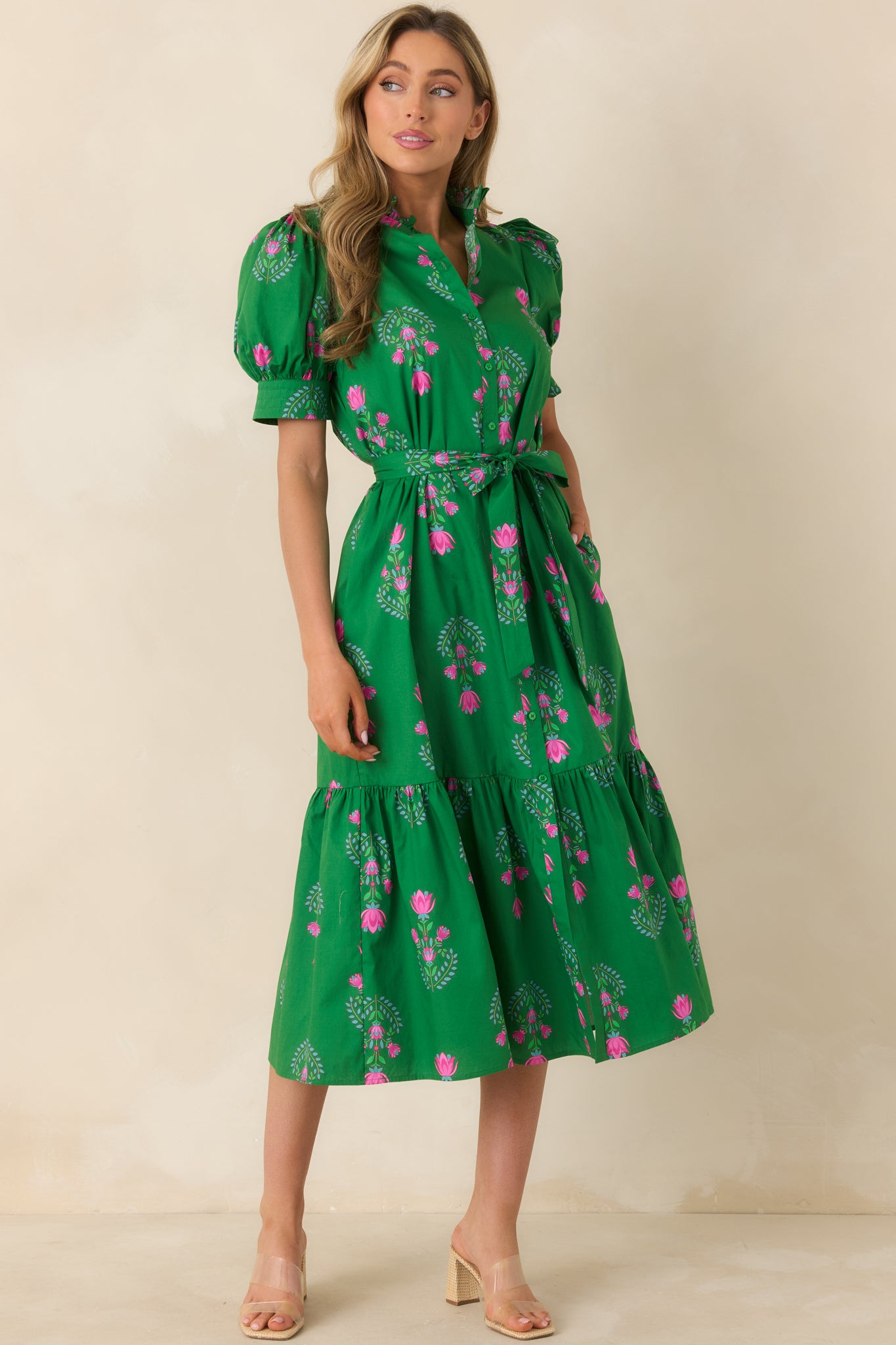 Structured green dress with puff sleeves, button-front closure, and playful floral pattern extending through the skirt.