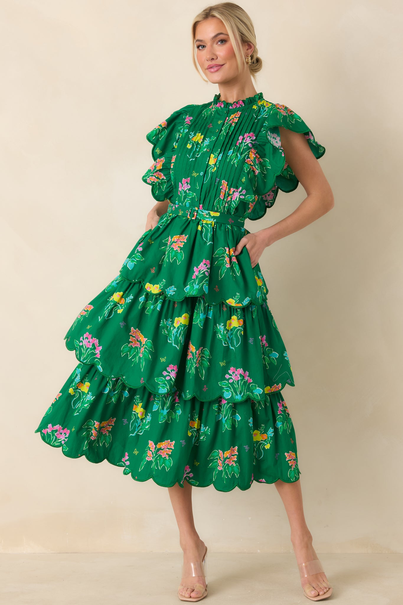 Green floral midi dress with pleated bodice, ruffle neckline, and coordinating waist belt.