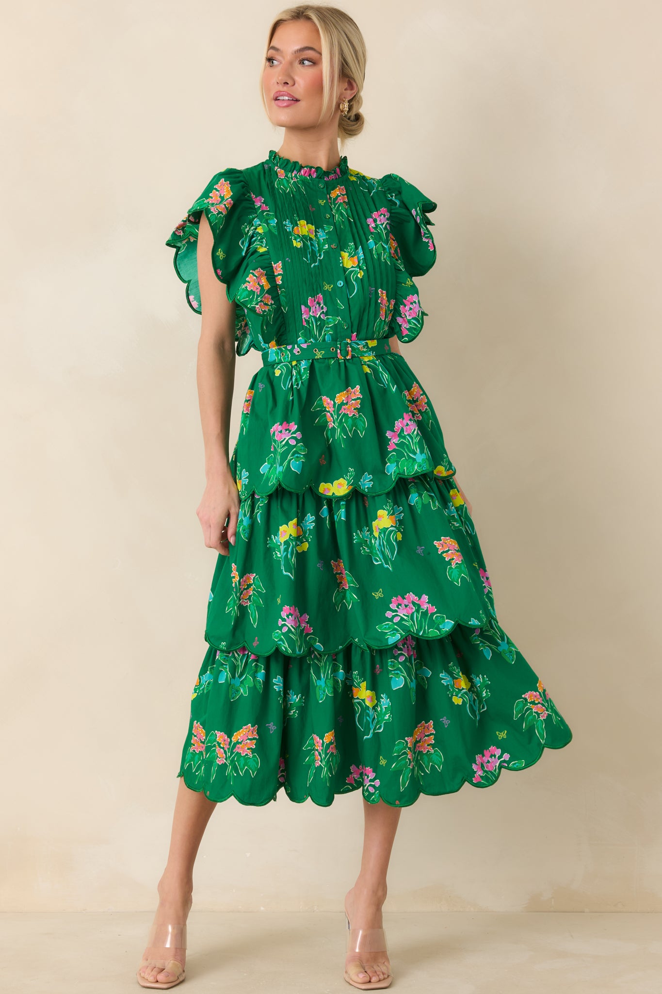 Vibrant green midi with playful floral print, belted waist, and feminine ruffle accents.