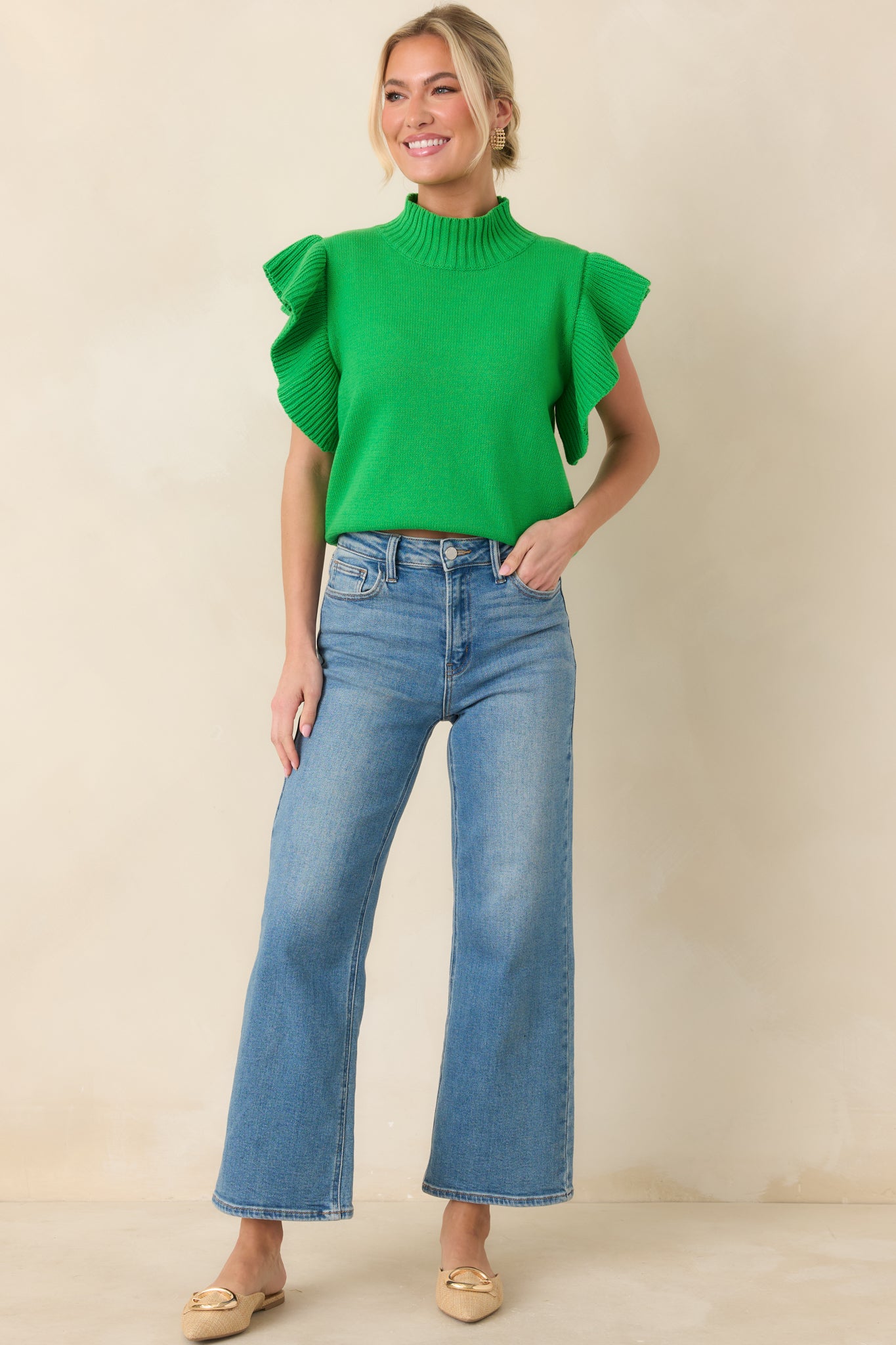 Green knit top featuring a ribbed mock neckline, ribbed hem, and textured flutter sleeves for added dimension.