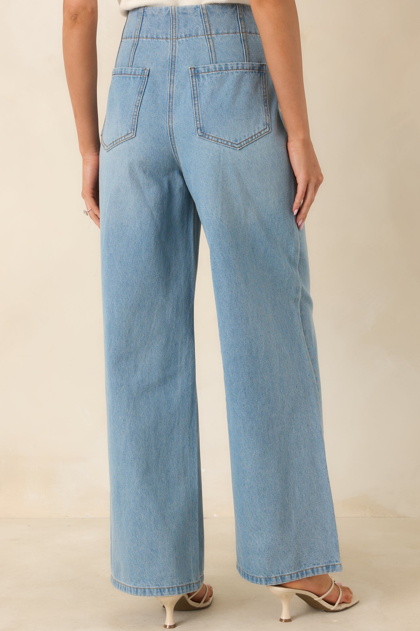 Rear view of the light wash high-rise jeans highlighting the back pockets, straight-leg cut, and relaxed fit.