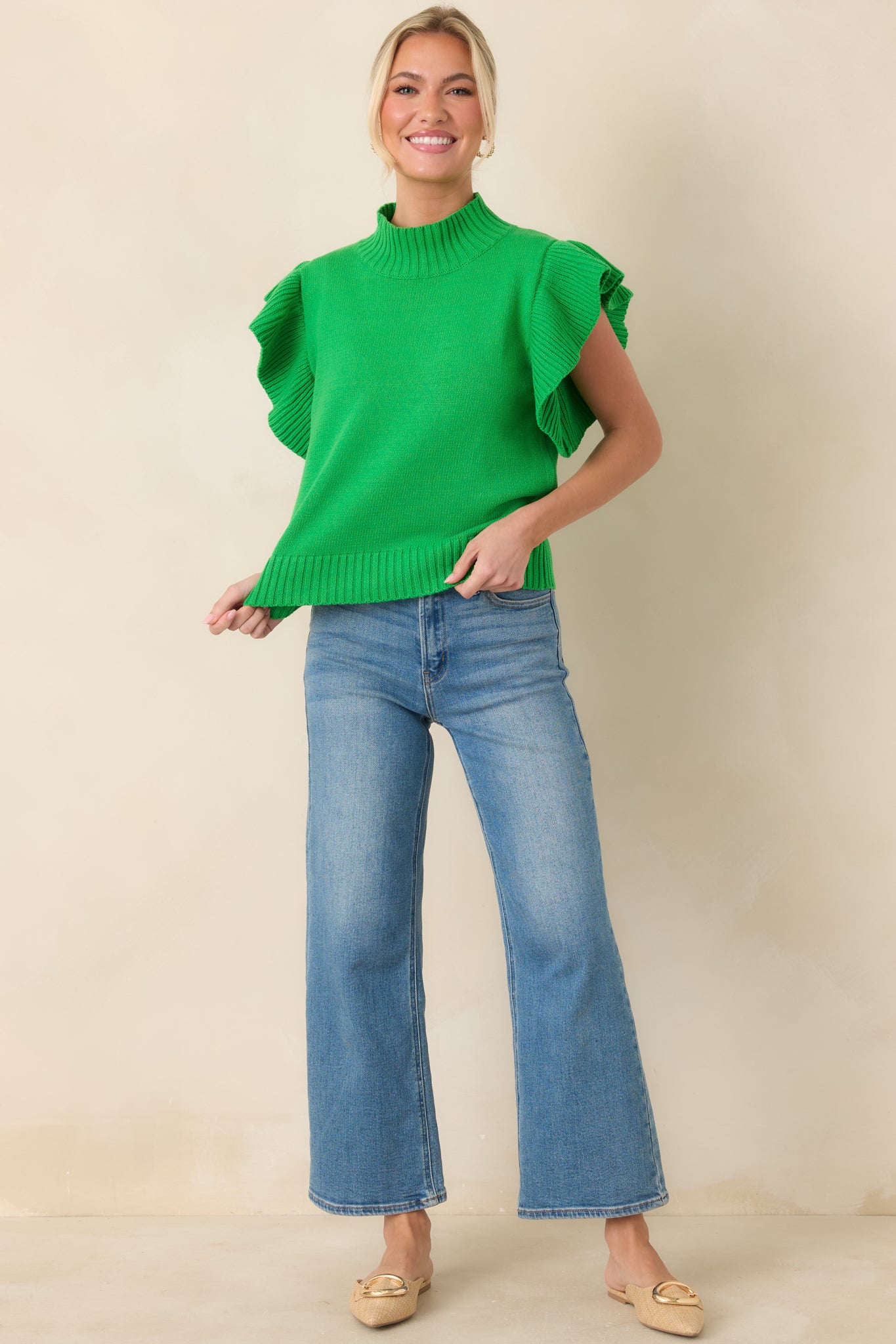 Green knit top with a comfortable drape, ribbed trim at the hem, and voluminous ribbed sleeve detailing.