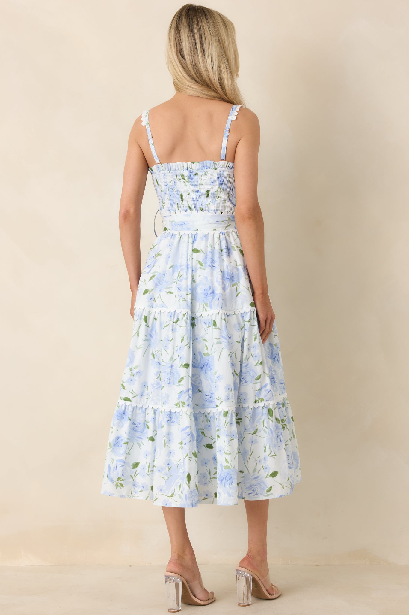 Rear view of blue maxi dress showing adjustable straps, smocked back detail, and tiered skirt.