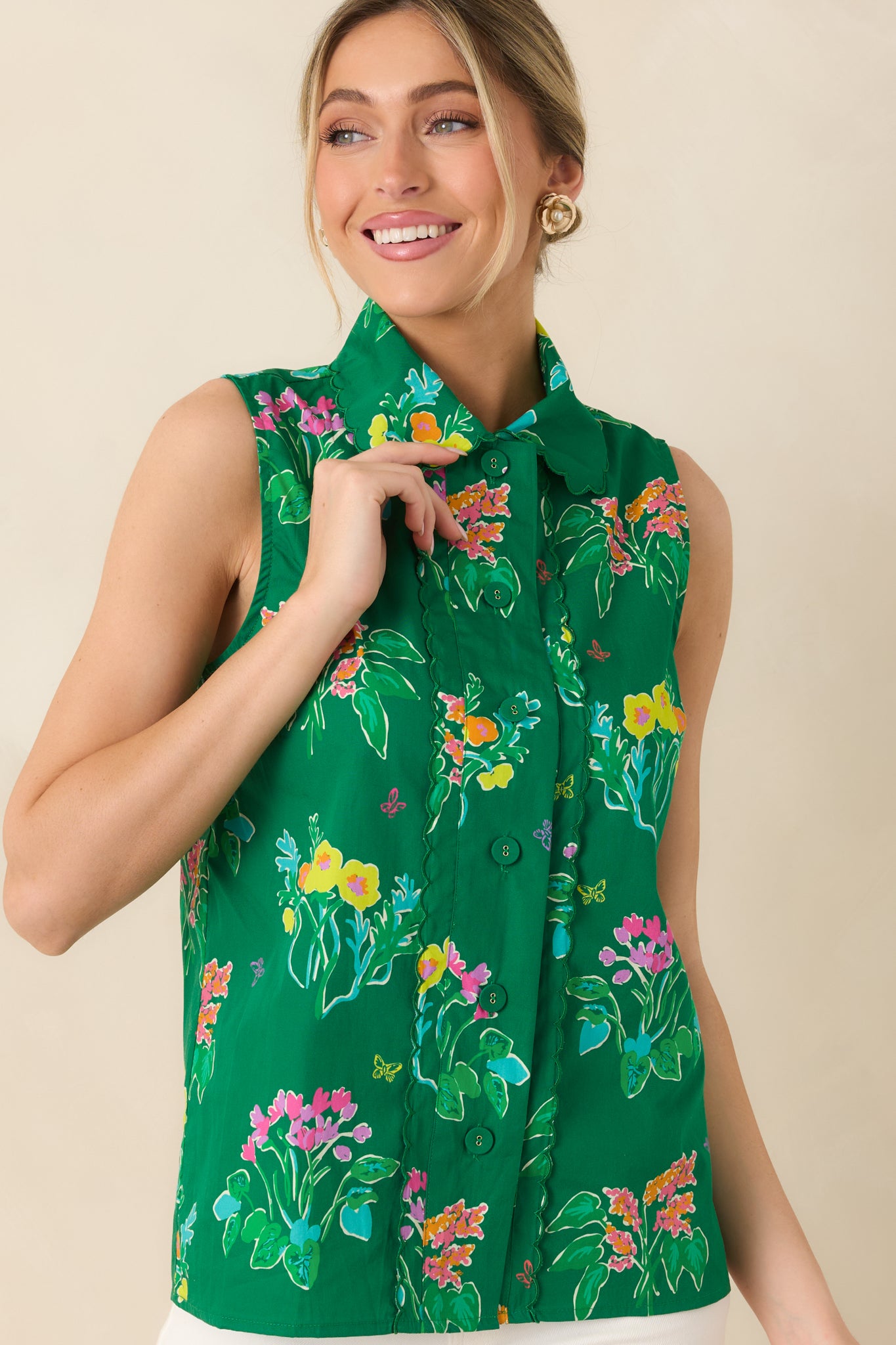 Front view highlighting fitted shape and vibrant green floral pattern of sleeveless blouse.