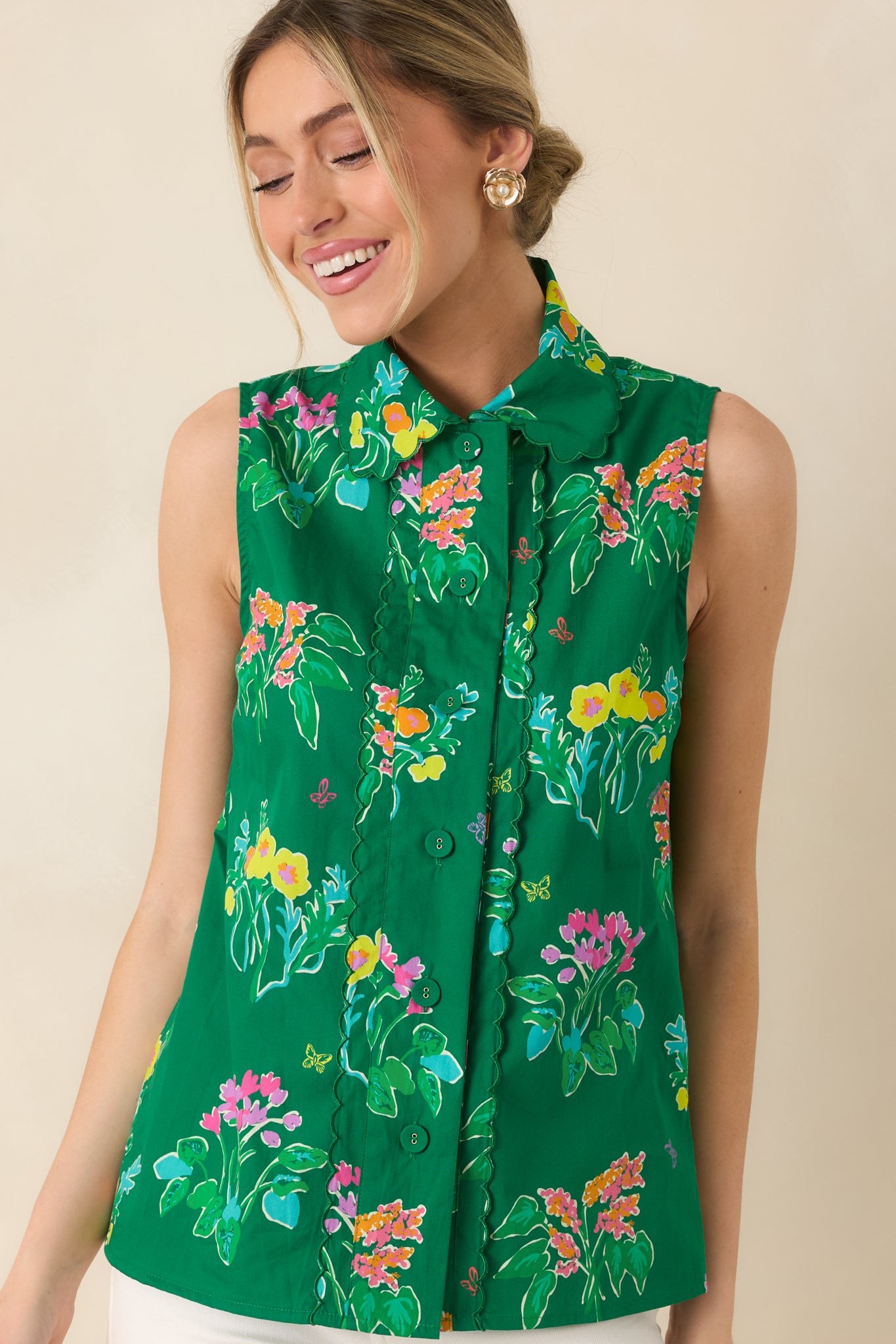 Close view of structured collar and button placket on green floral sleeveless blouse.