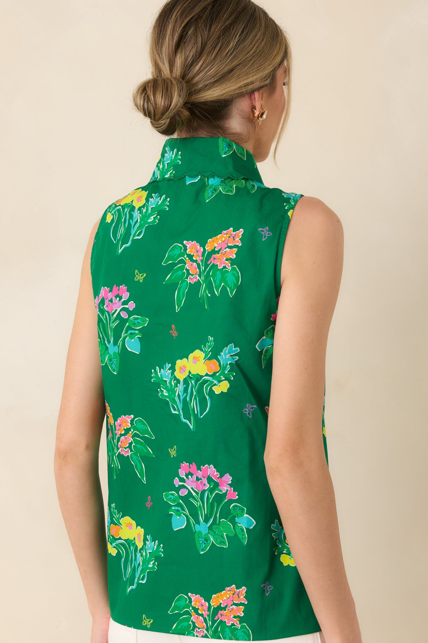 Rear view of sleeveless blouse revealing smooth tailored back and flowing fit in cheerful floral print.
