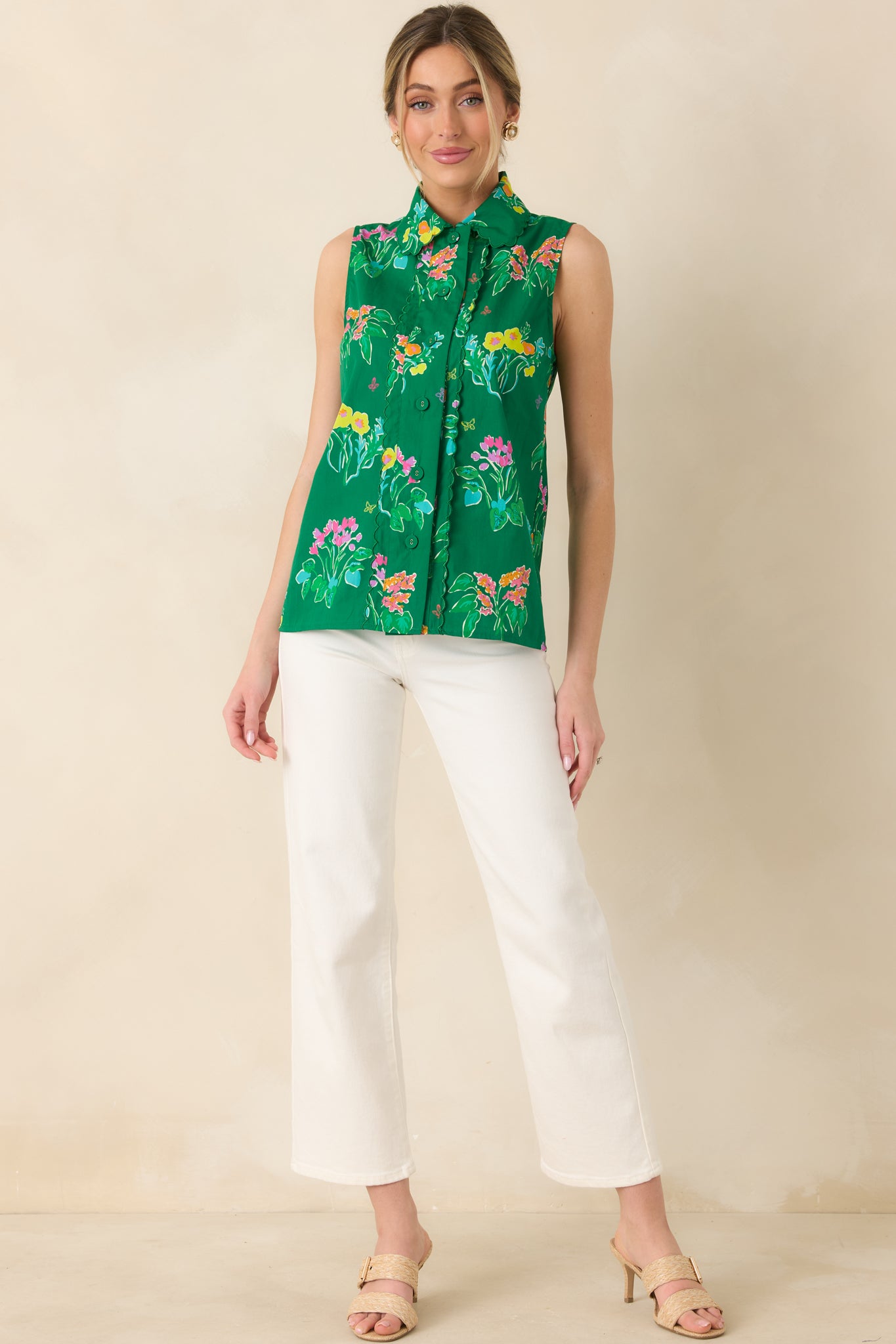 Sleeveless blouse in bright green floral print with structured collar and button-front design.