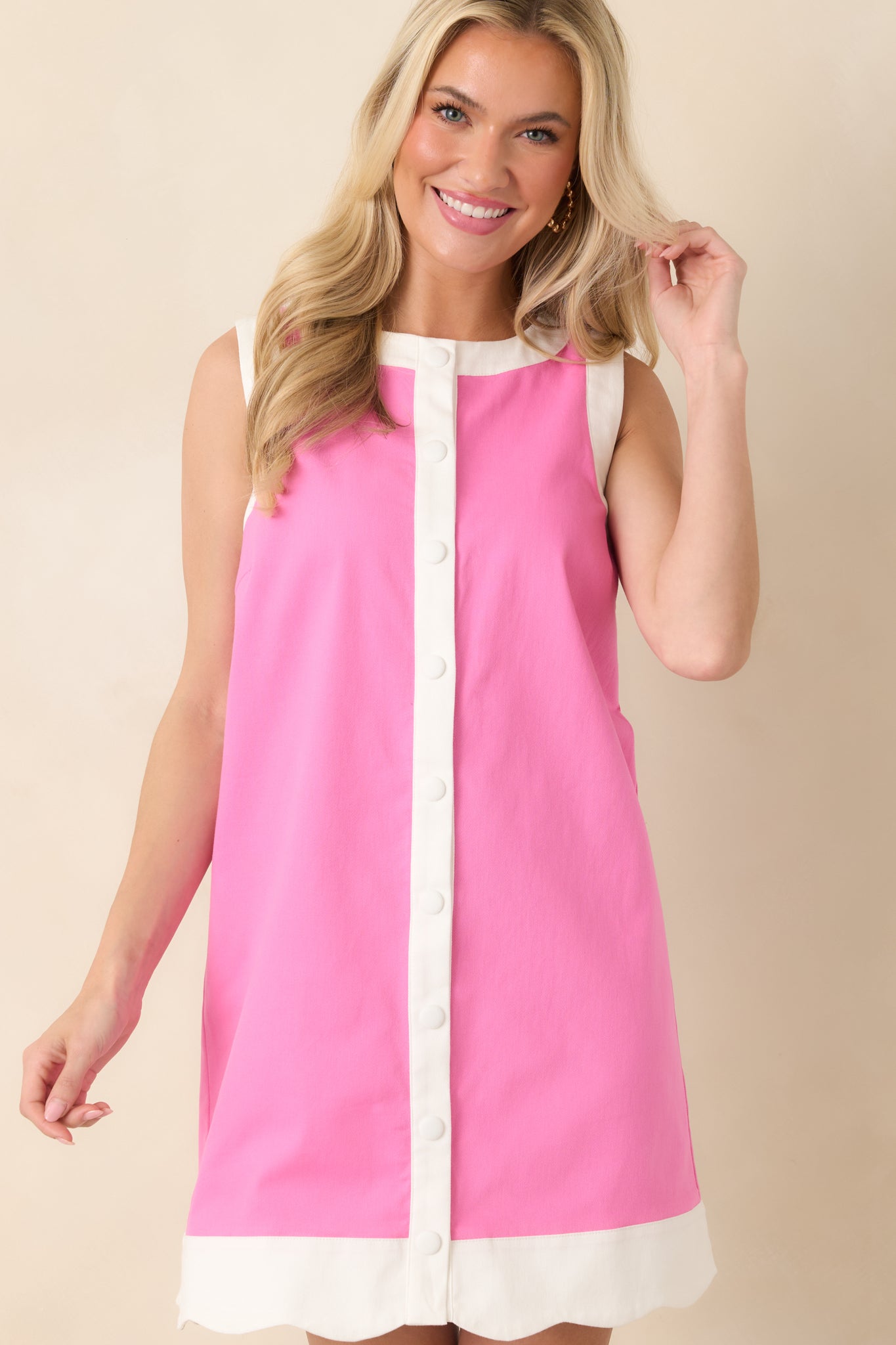 Cropped view highlighting the pink cotton fabric, contrast trim at the neckline and arm openings, and the front snap-button placket.