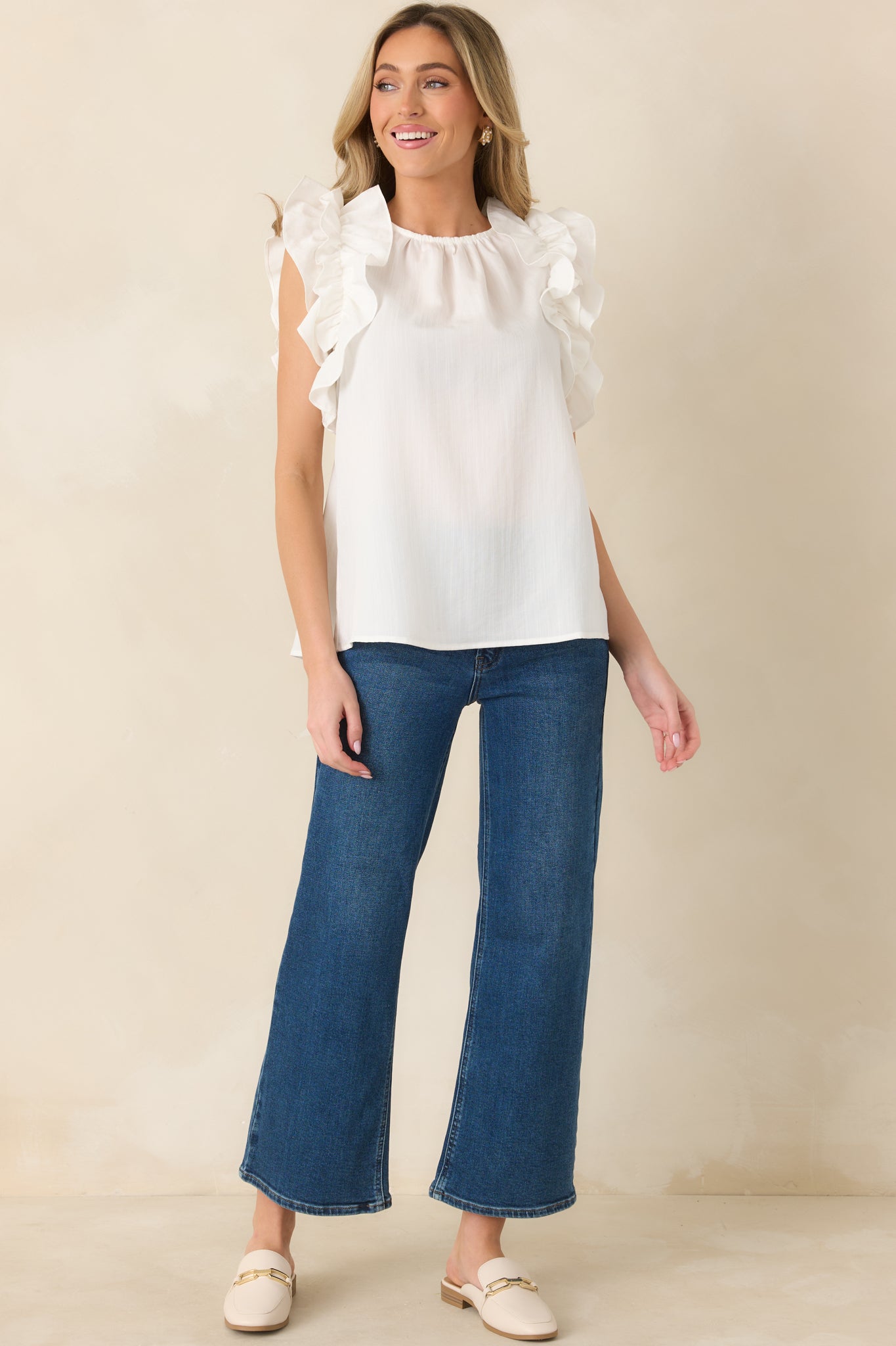 High neck ivory blouse featuring layered ruffle detailing at the shoulders.