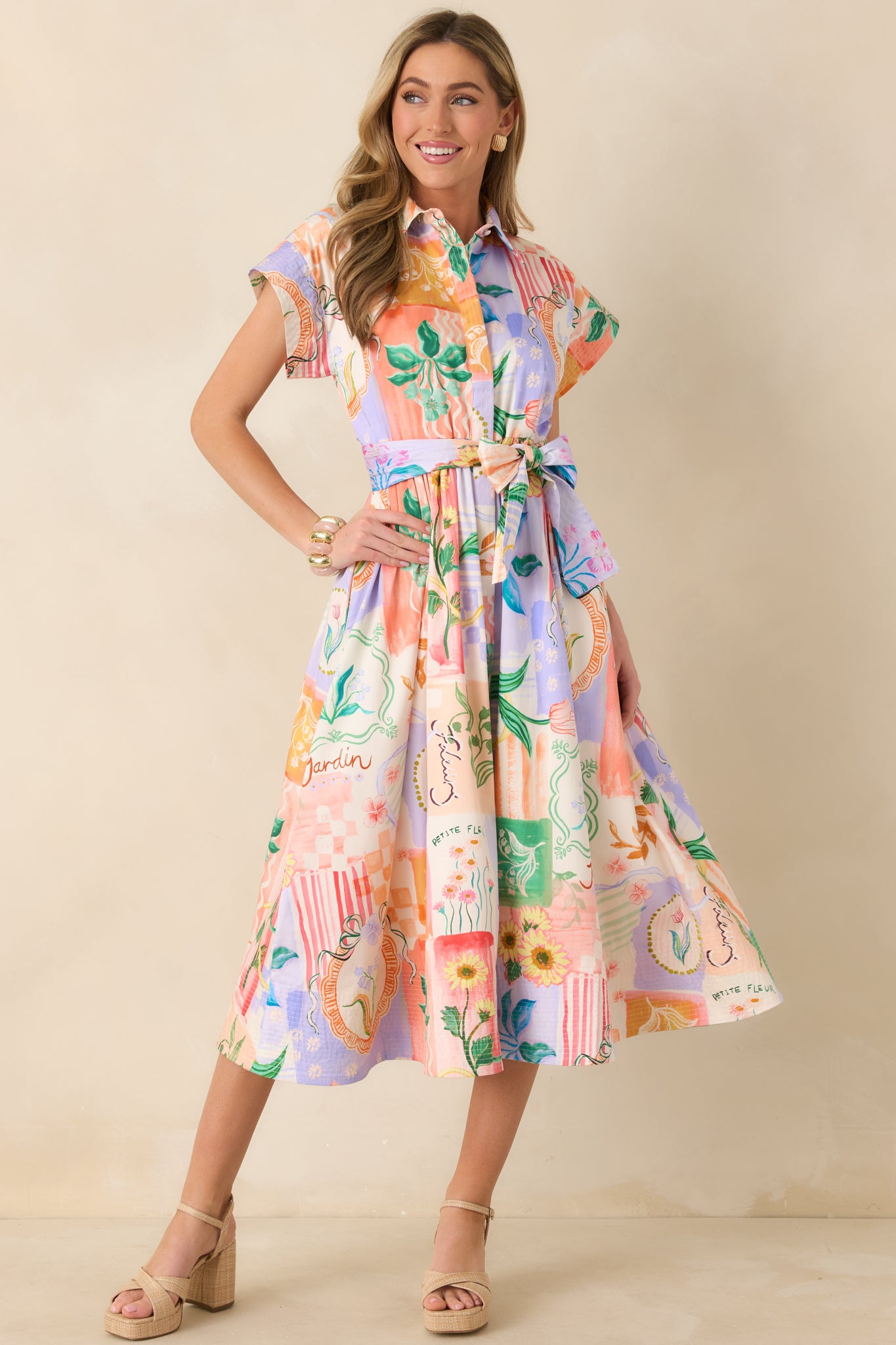 Peach and multicolor floral midi dress designed with short sleeves, self-tie belt, and a polished button-front silhouette.