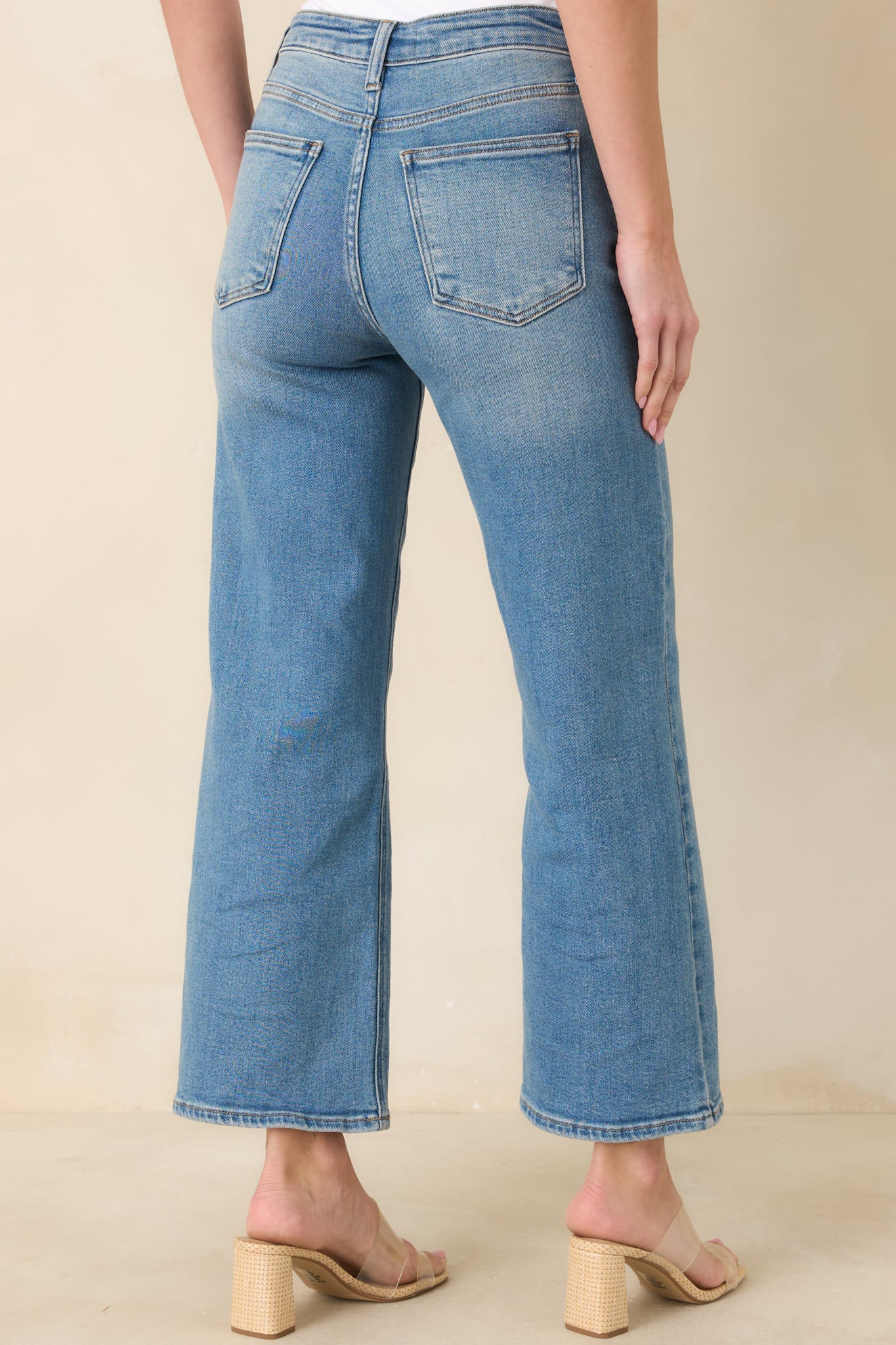 Back view of light wash jeans showing high-rise fit and functional back pockets.