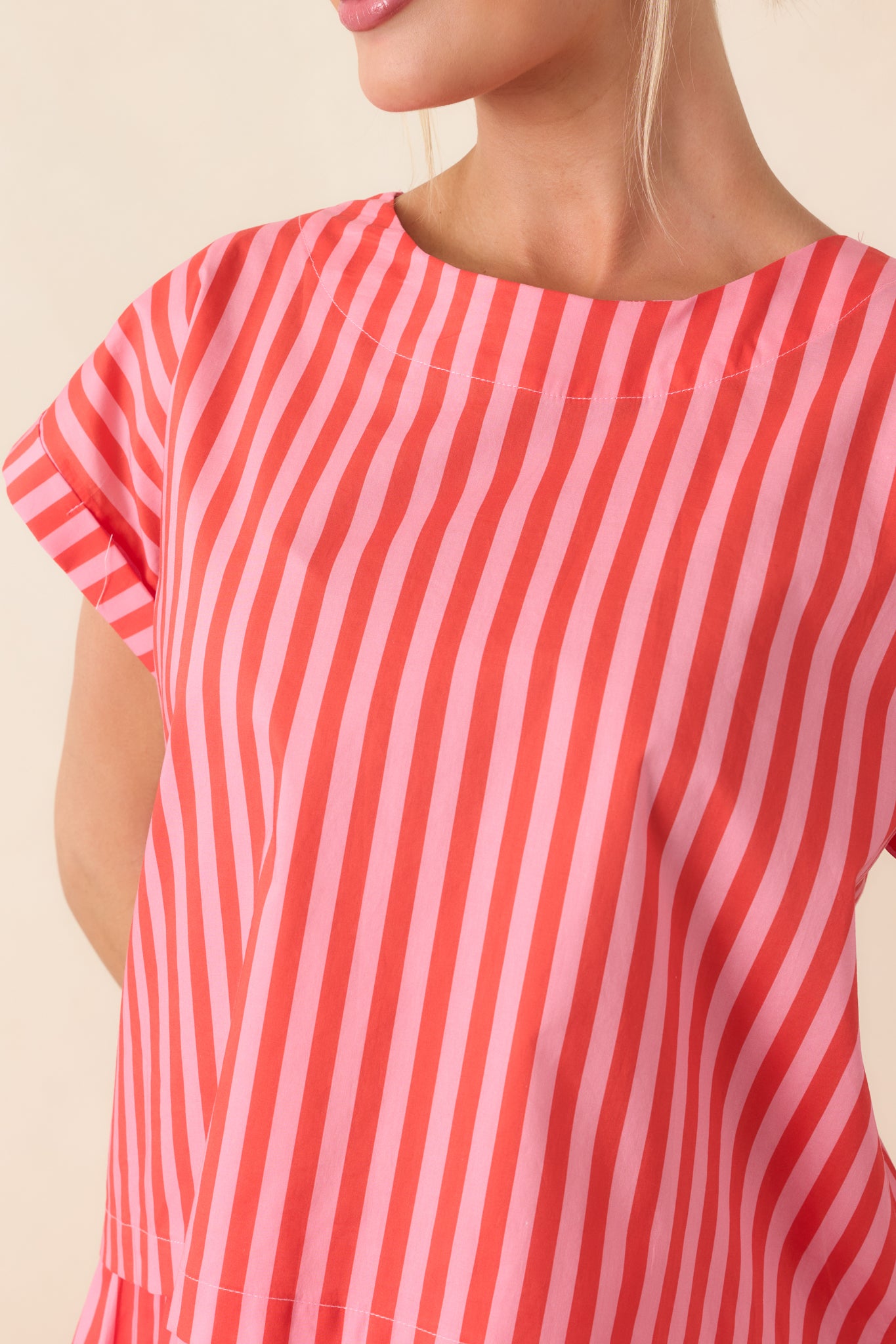 Detailed view of the cotton fabric showcasing crisp vertical orange and pink stripes with smooth stitching and structured finish.