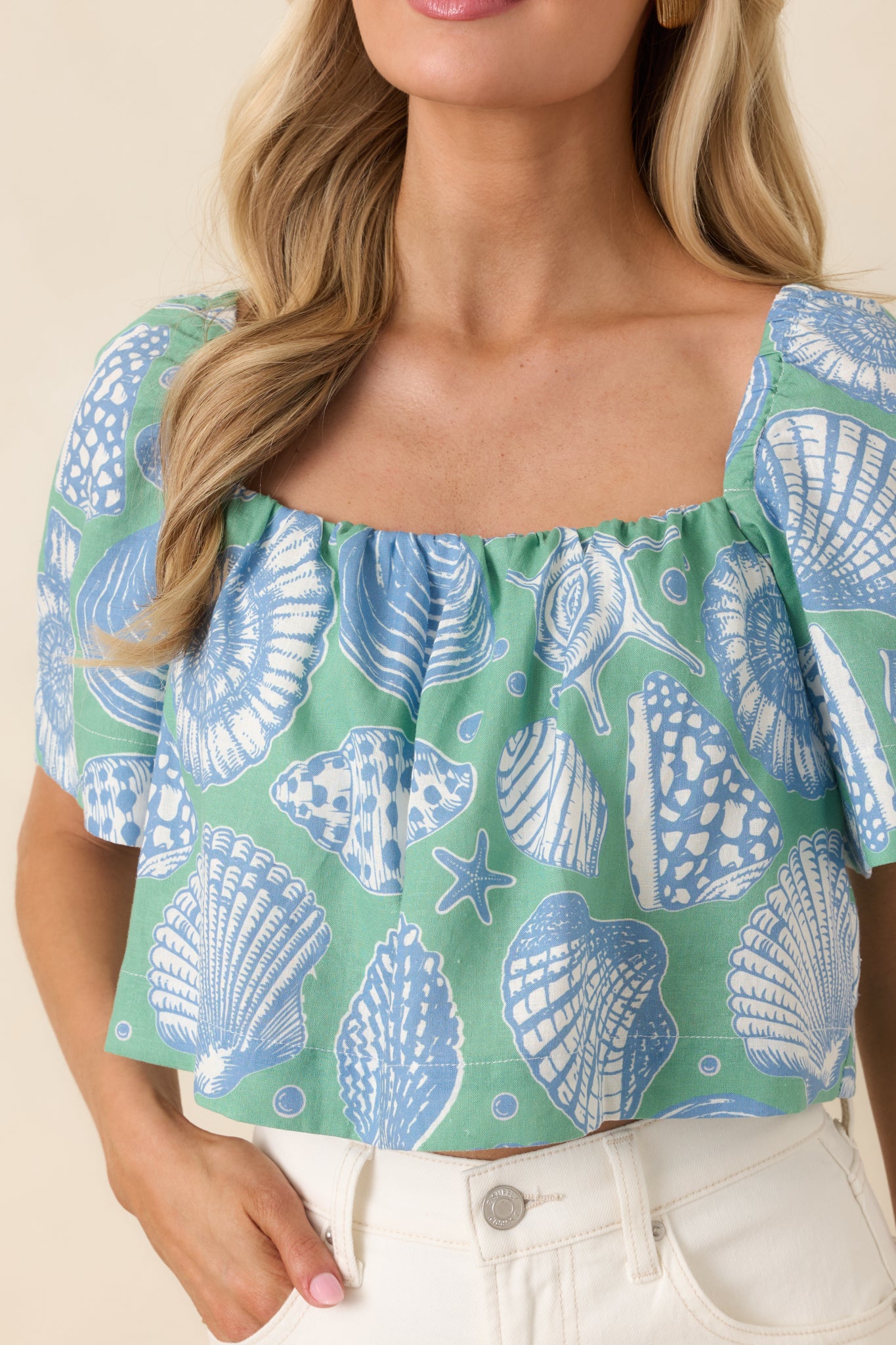 Close-up of the shell motif print in soft blue and ivory tones on the breathable cotton fabric.