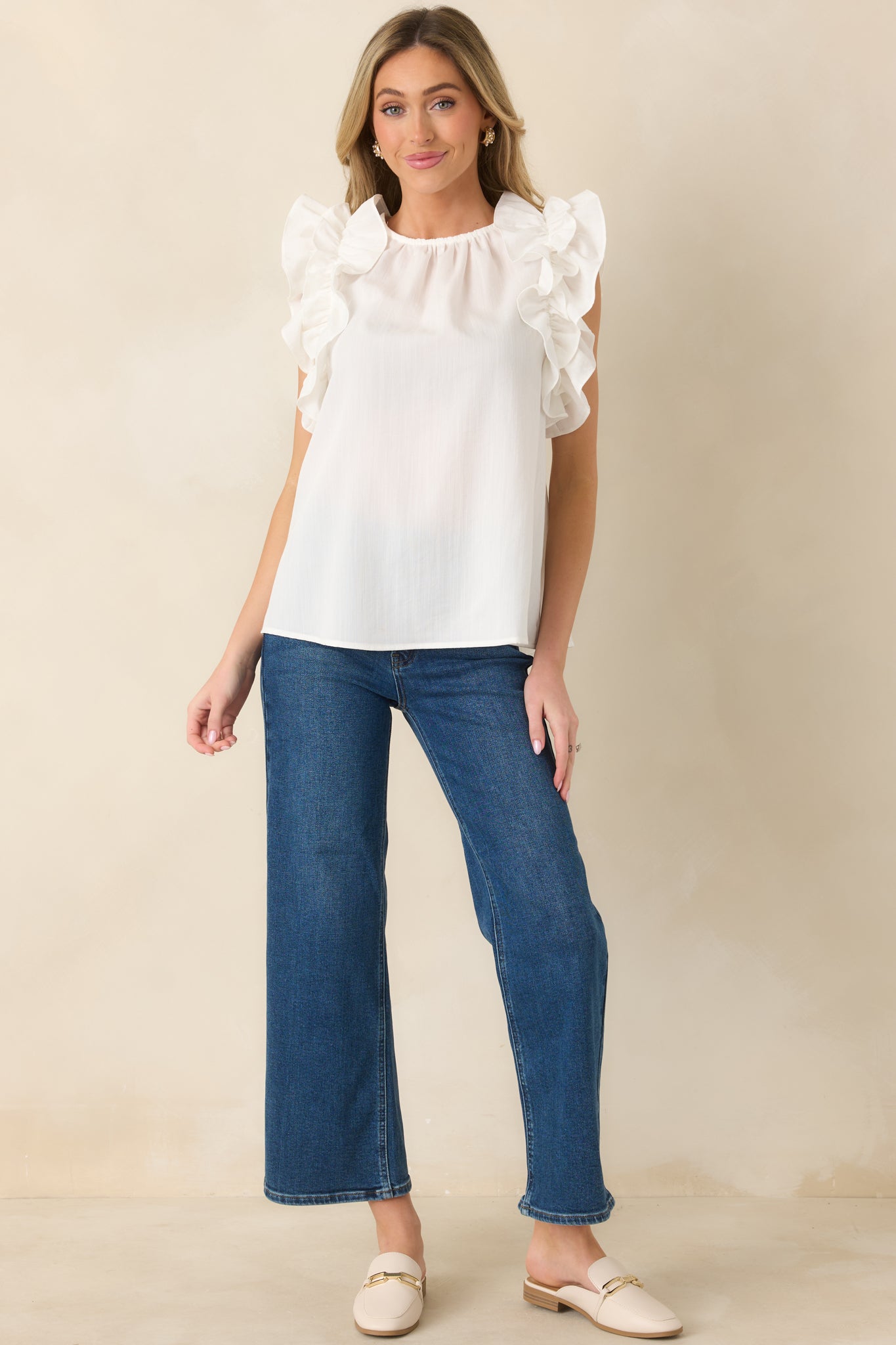 Ivory top showcasing structured crew neckline and subtle shoulder texture.