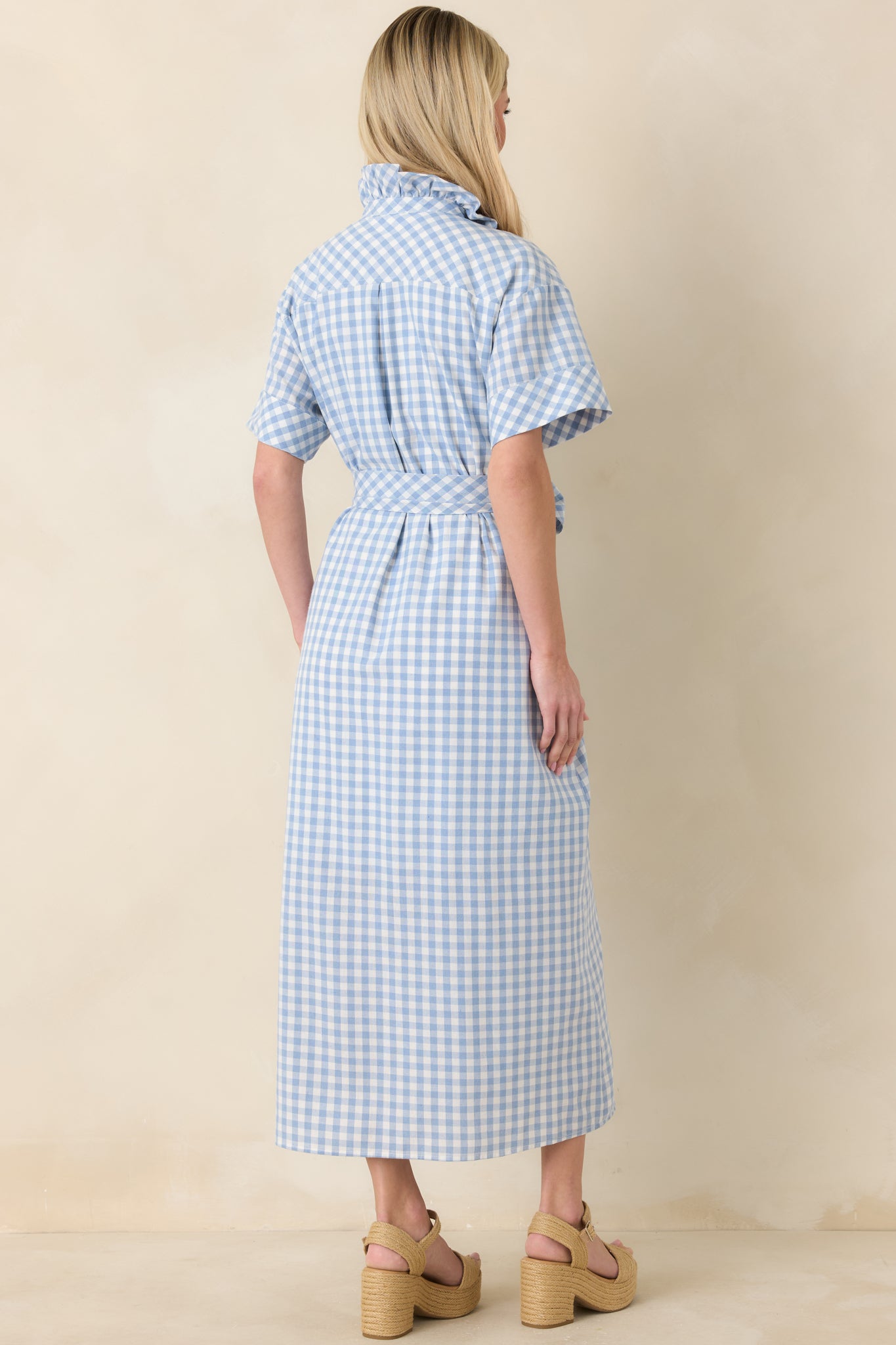 Back view of the blue and white gingham maxi dress featuring relaxed fit, flowing skirt, and removable belt tie.