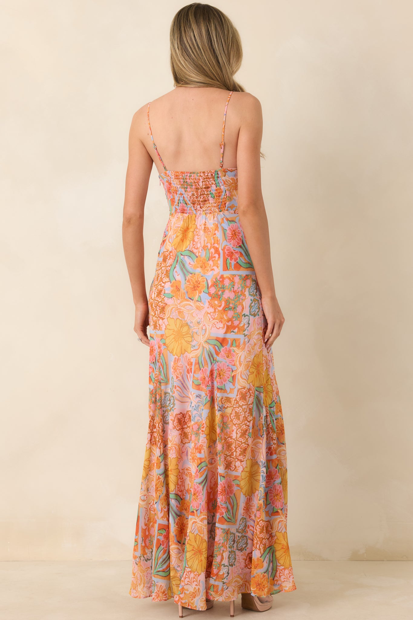 Rear view of the flowing maxi dress with smocked back panel, adjustable straps, and floral skirt cascading gracefully from the fitted bodice.
