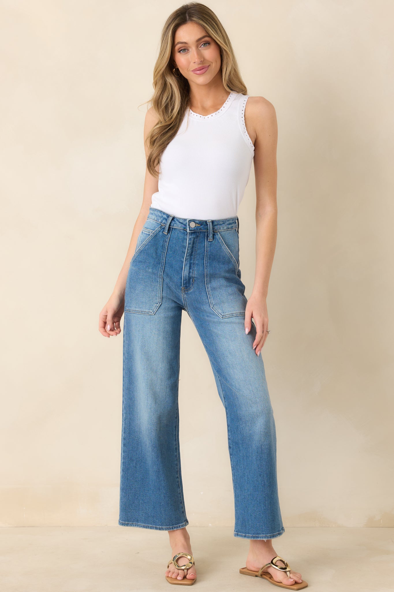 White ribbed cotton tank with fitted silhouette, round neckline, and sleeveless design featuring delicate eyelet trim.