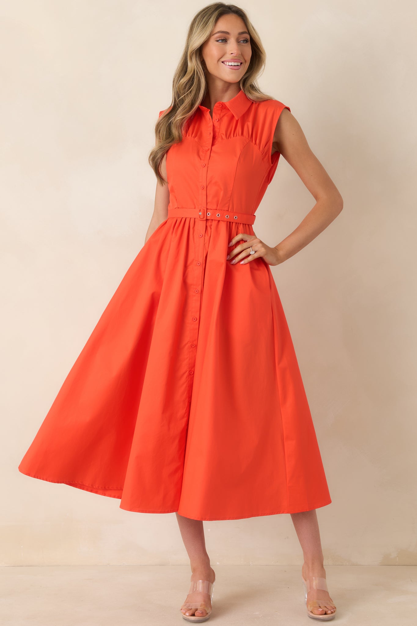 Vibrant sleeveless midi dress with crisp collar, button-front closure, and waist-cinching belt.