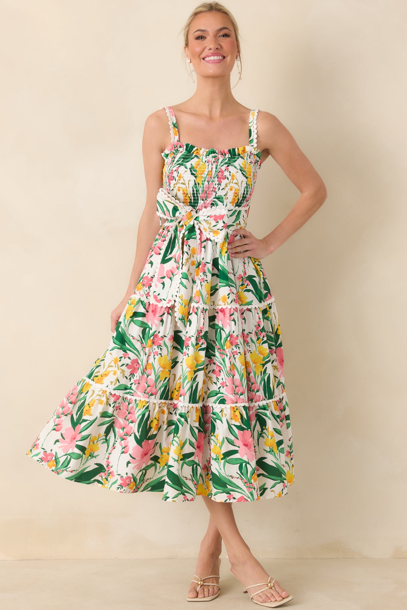 Lightweight floral midi showcasing a statement bow at the waist and flowing tiered silhouette.